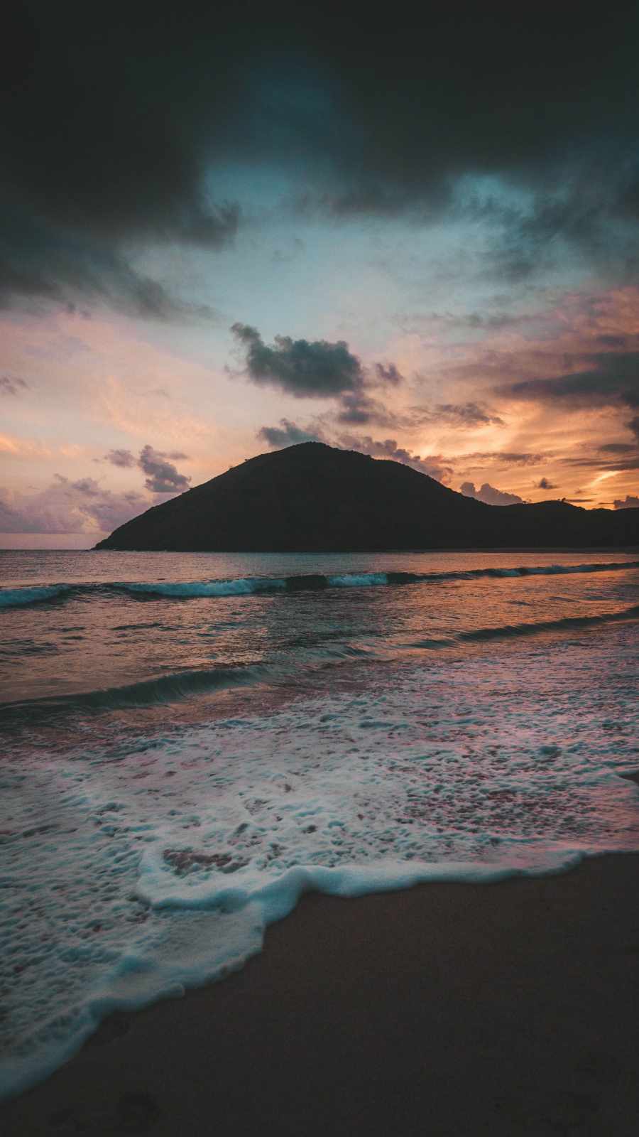 A sunset over a mountain and the ocean - Beach, mountain