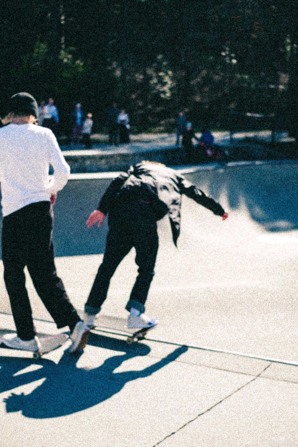 A couple of people riding skateboards at a skate park photo