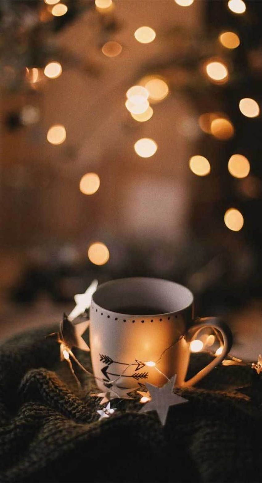 A cup of coffee with lights in the background - Cozy