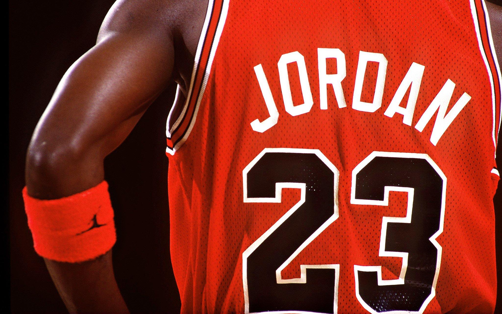 The back of a basketball player wearing a jersey that says Jordan on it. - Michael Jordan
