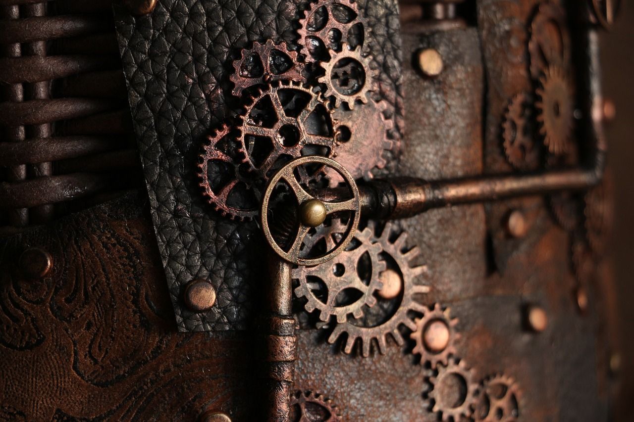 A close up of a book with gears and a key. - Steampunk