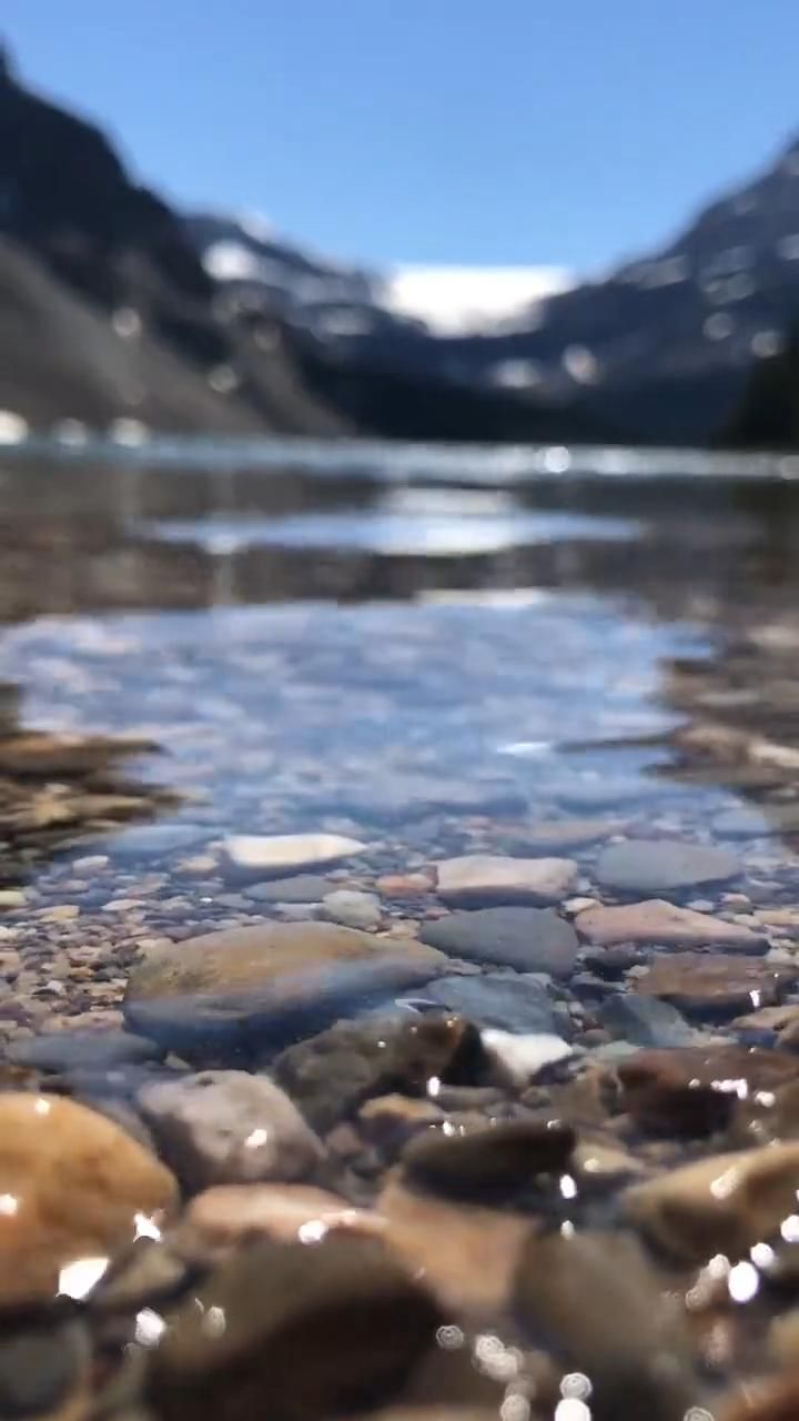 A video of a lake with rocks in it - River