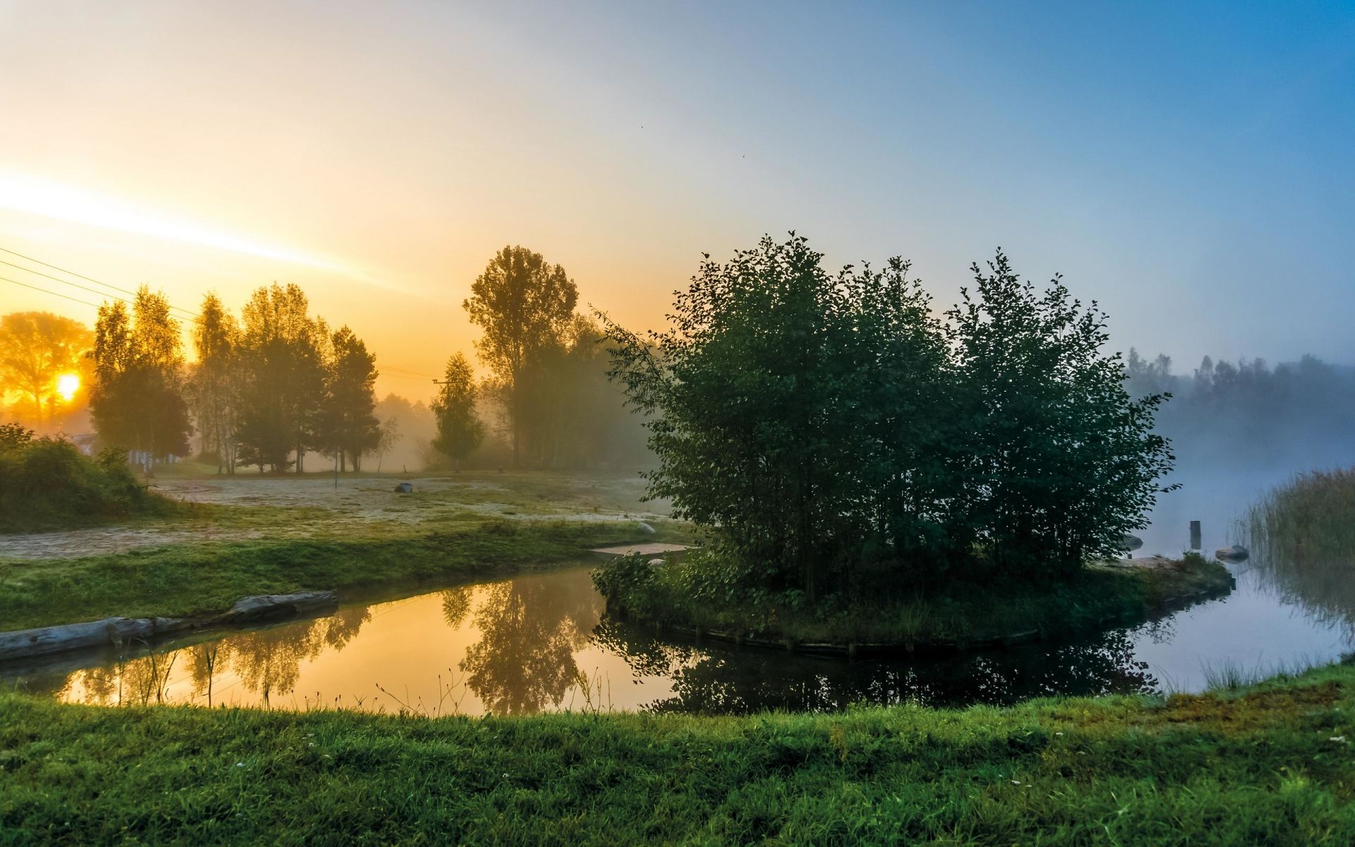 A sunrise over the water with trees in it - River