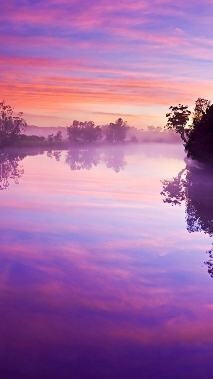 A sunset over the water with fog - River