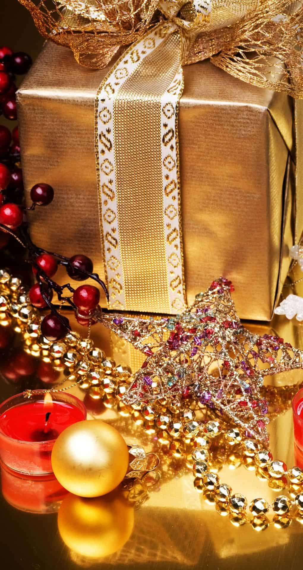 Golden gift box with a bow, golden beads, red candles and a star. - Christmas iPhone