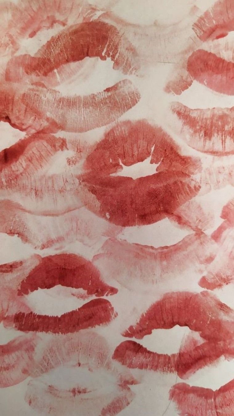 A sheet of paper with many lips imprints in red and pink shades - Lips