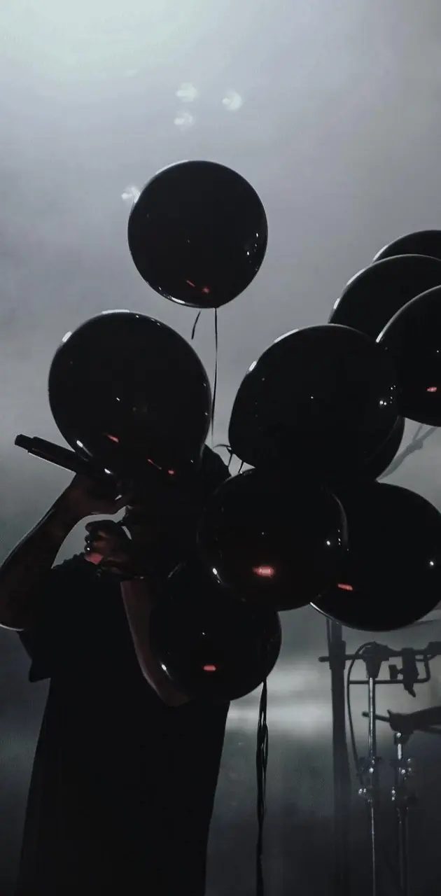 A person holding a bunch of black balloons - Balloons