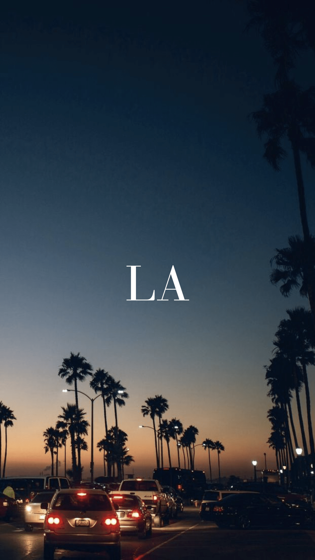 LA at night with palm trees and cars on the road - Los Angeles, California