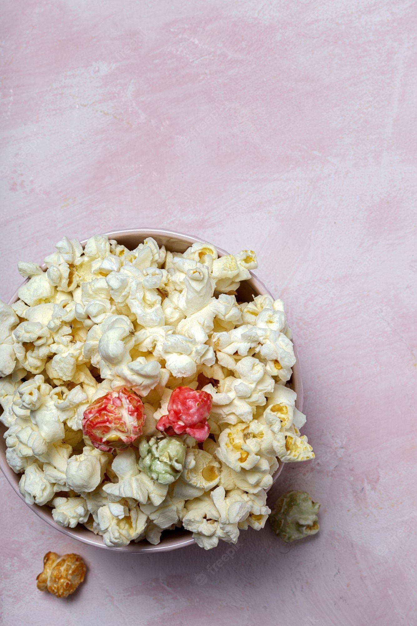 Premium Photo. Homemade popcorn on colored table with high contrast light. snack concept