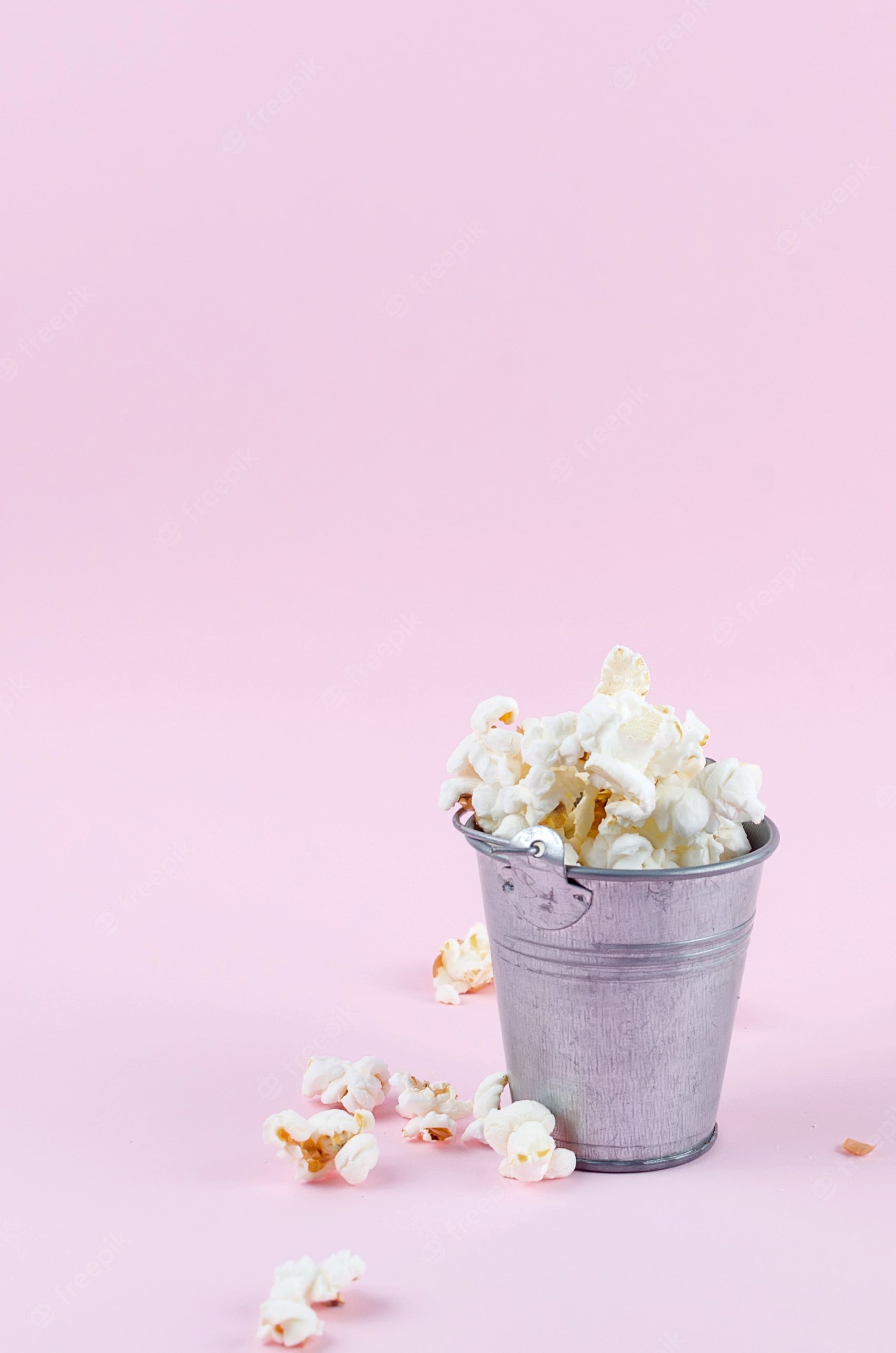 Premium Photo. Popcorn in a bucket on pink