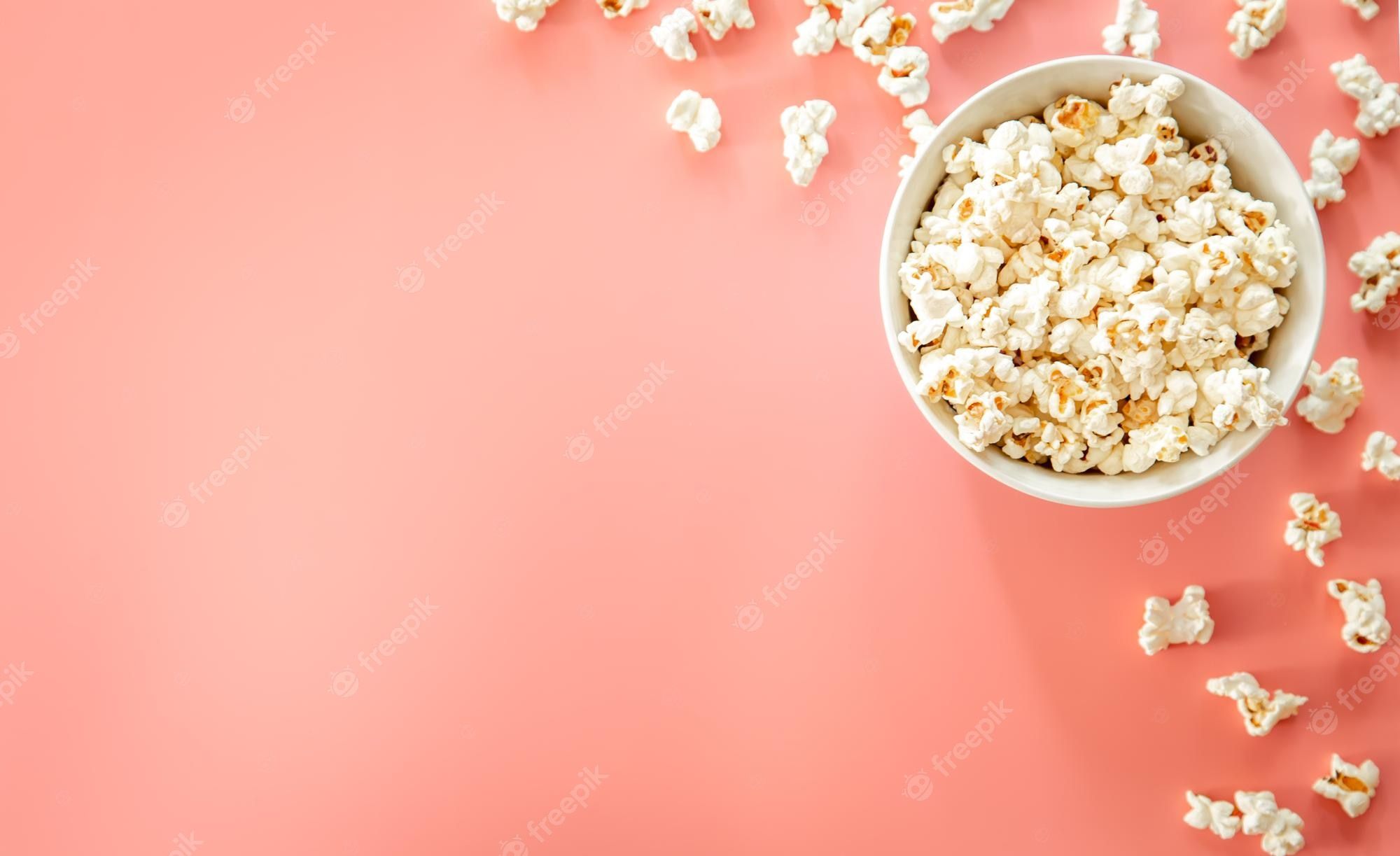 Free Photo. Popcorn plate on pink background flat lay