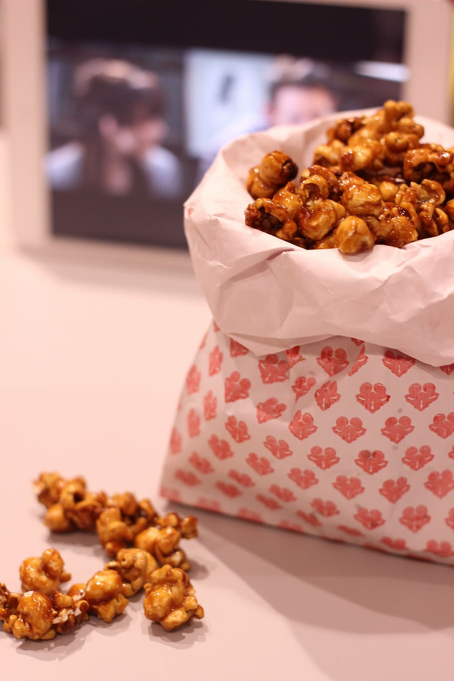 A bag of caramel popcorn sits on a table. - Popcorn