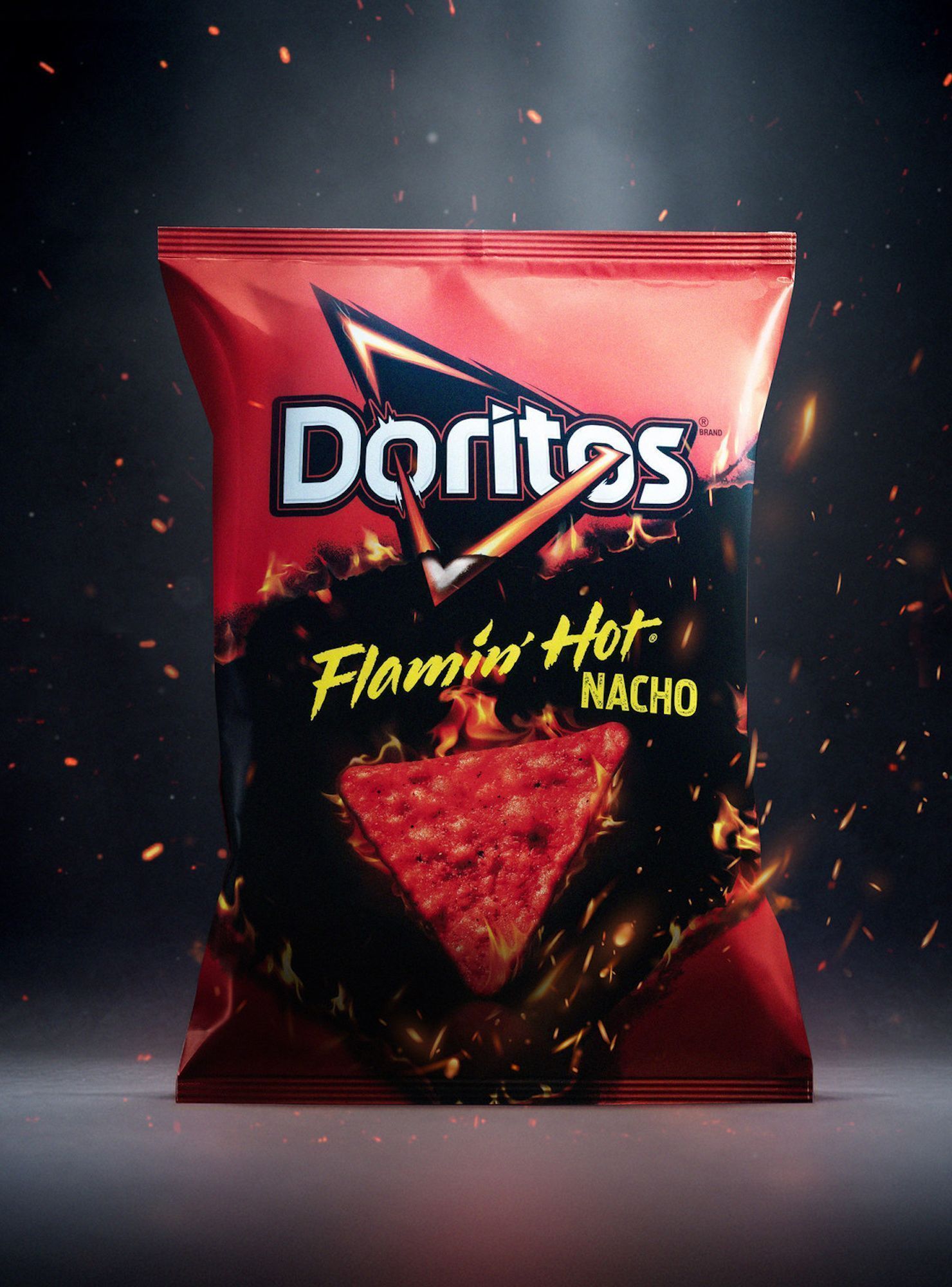 A bag of Doritos Flaming Hot Nacho tortilla chips on a black background with sparks - Doritos
