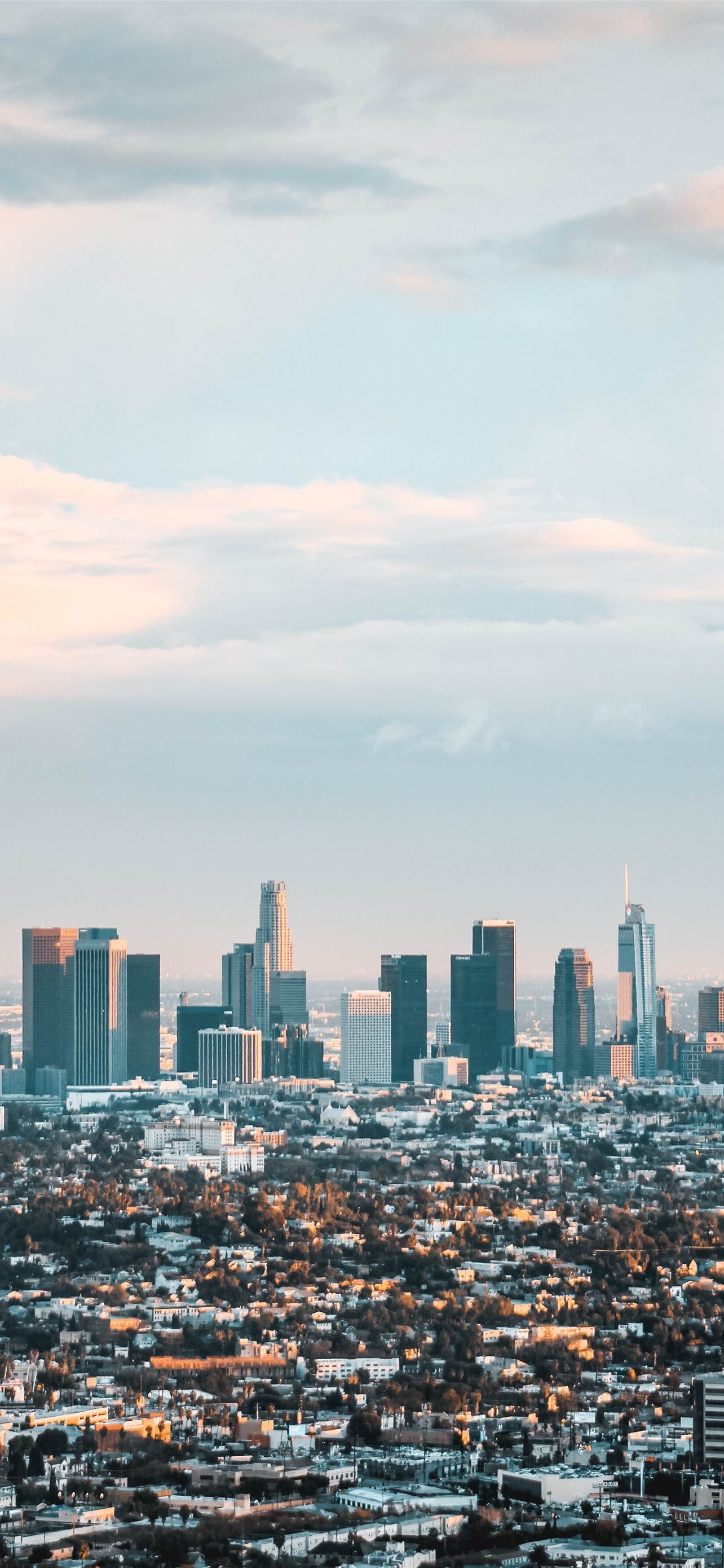 A city skyline with tall buildings and a blue sky - Los Angeles
