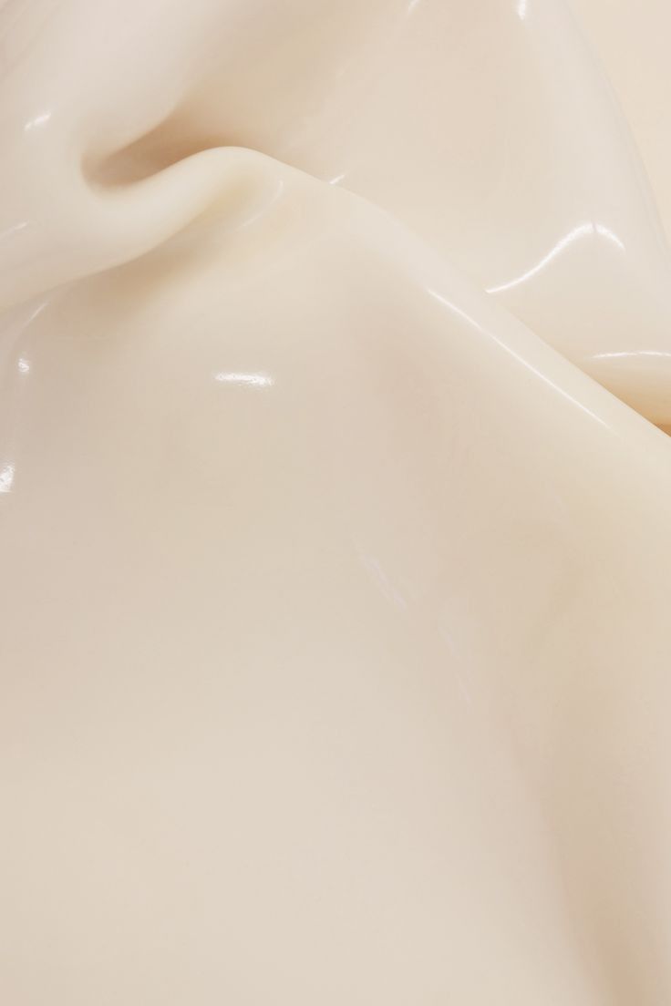 A close-up of a white sculpture with smooth lines. - Cream