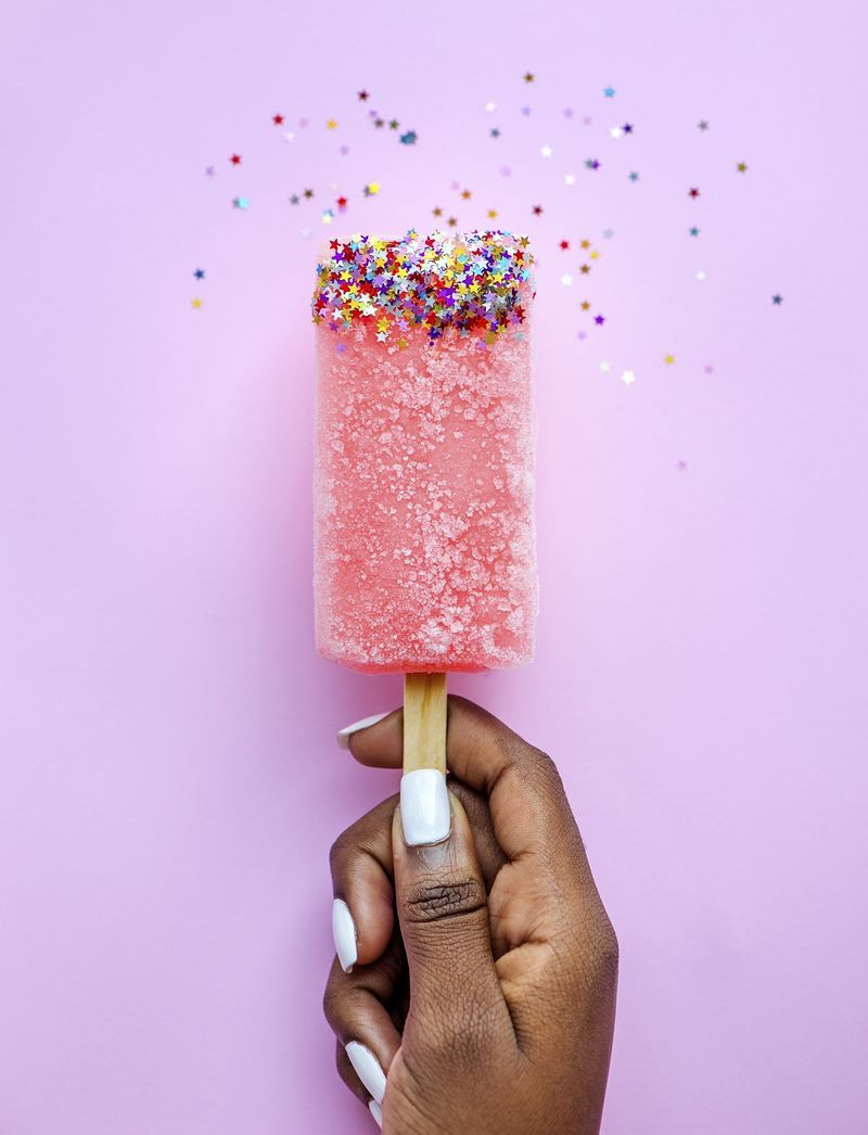 A person holding up an ice cream cone with sprinkles - Ice cream