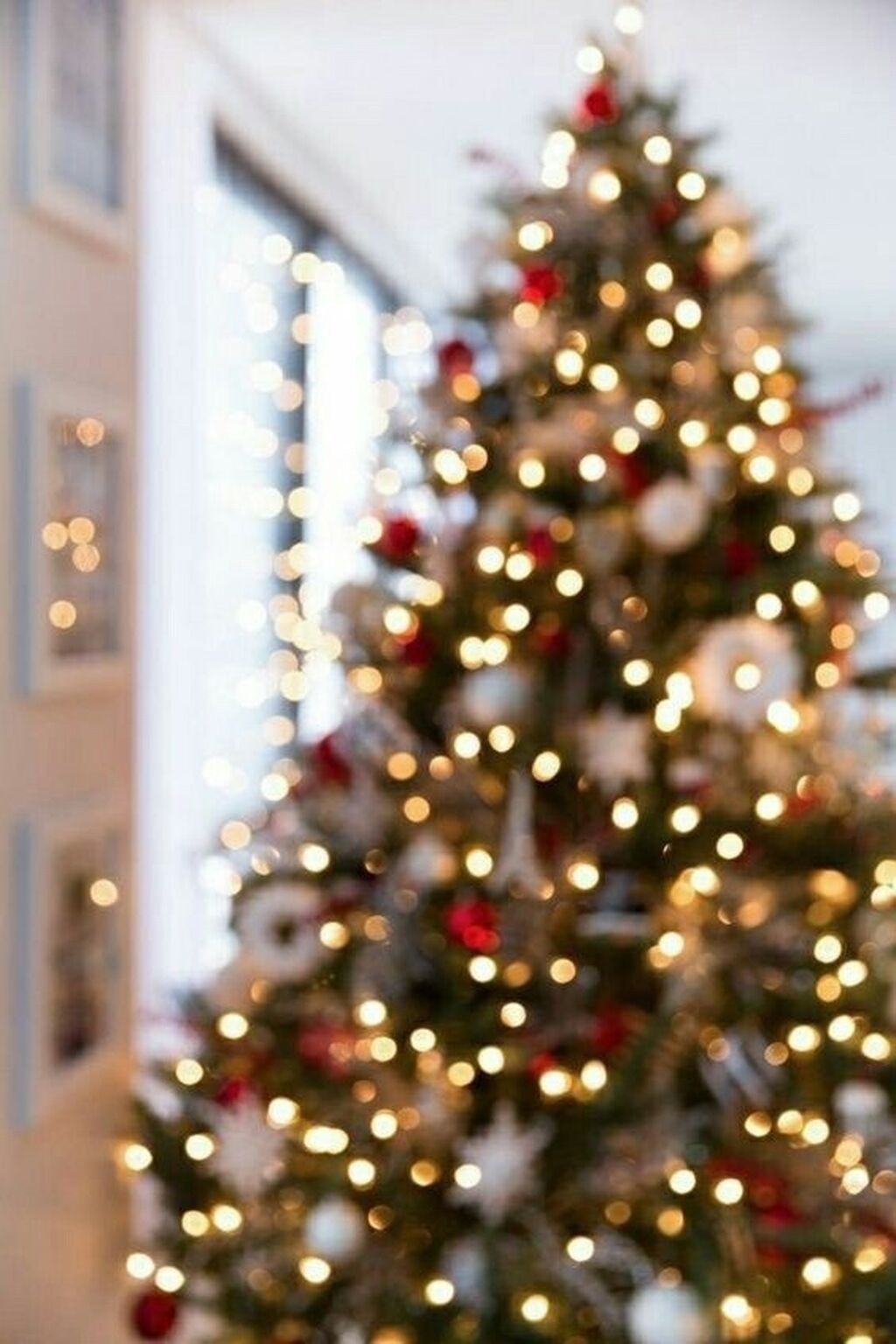 A blurry Christmas tree with white and red ornaments. - White Christmas