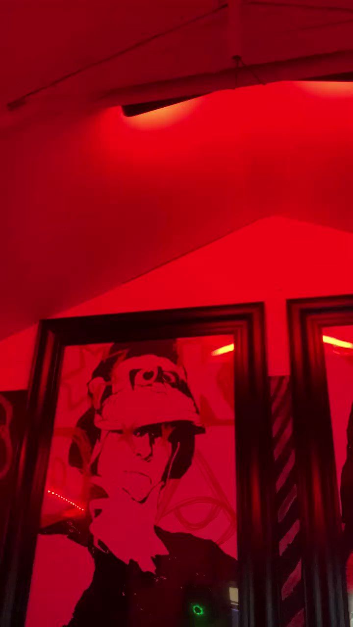 A red-lit room with a framed picture of a soldier. - Neon red