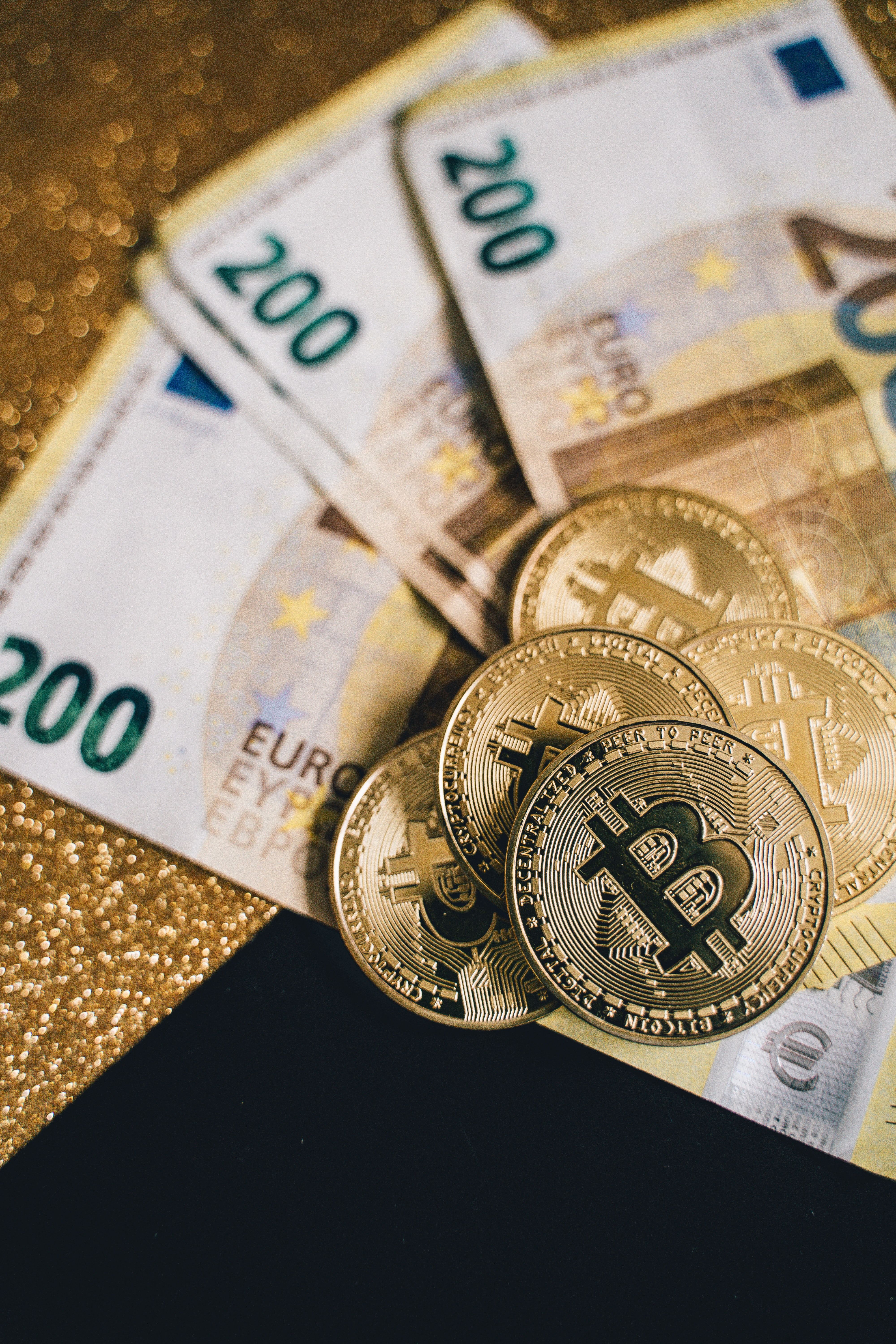 Bitcoin and euros on a gold background - Money