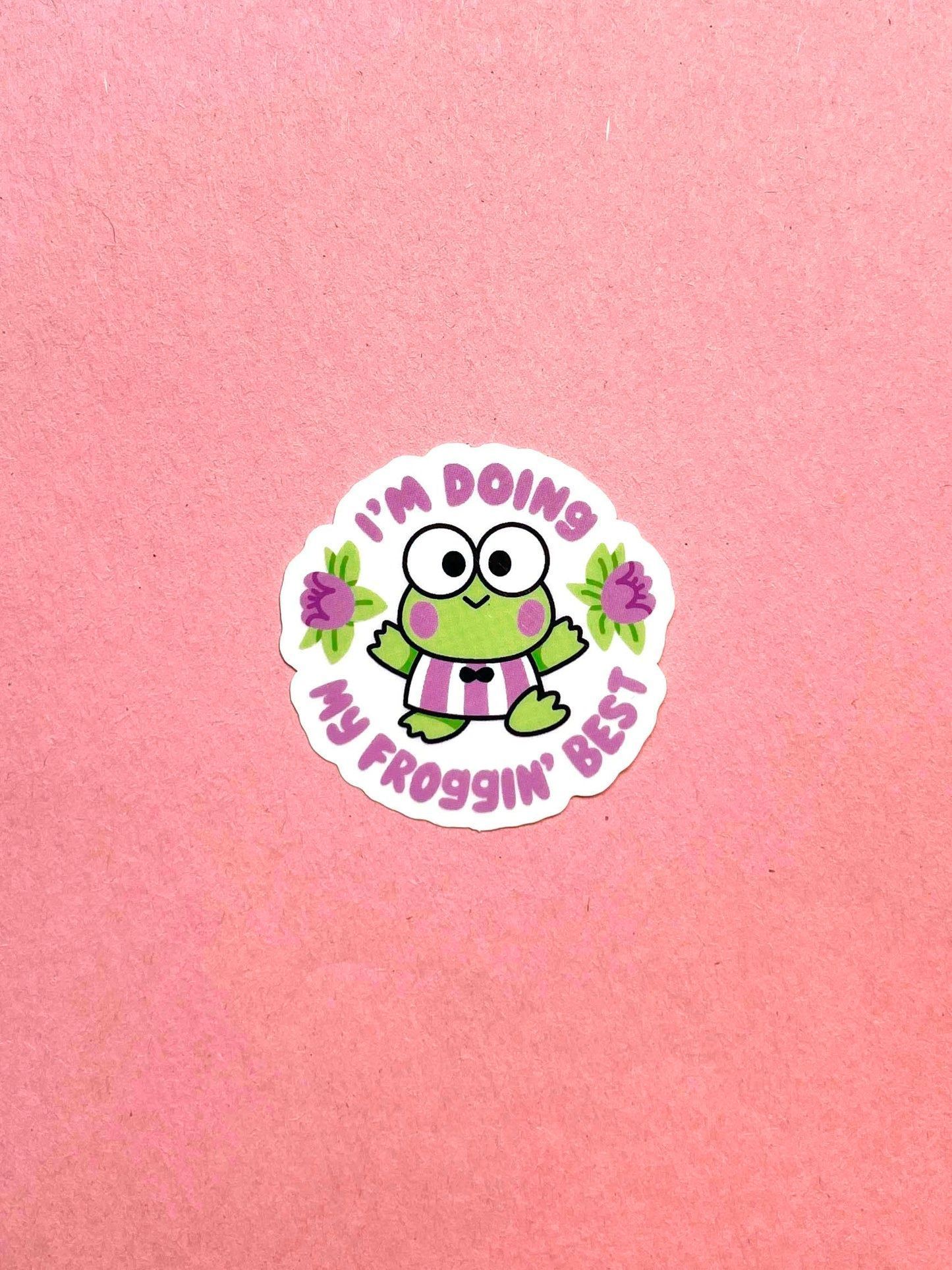 A sticker with a green frog holding flowers and the words 