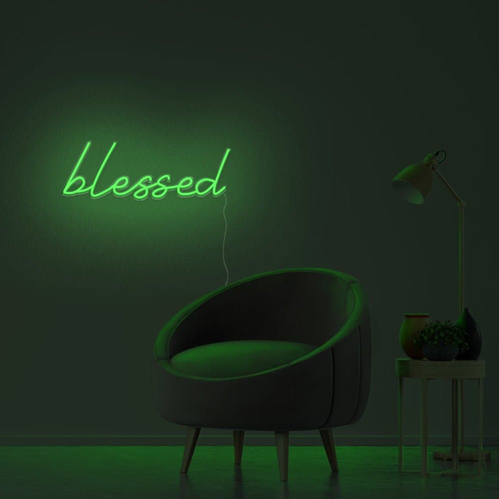 A green neon sign that says 'blessed' in a dark room. - Neon green