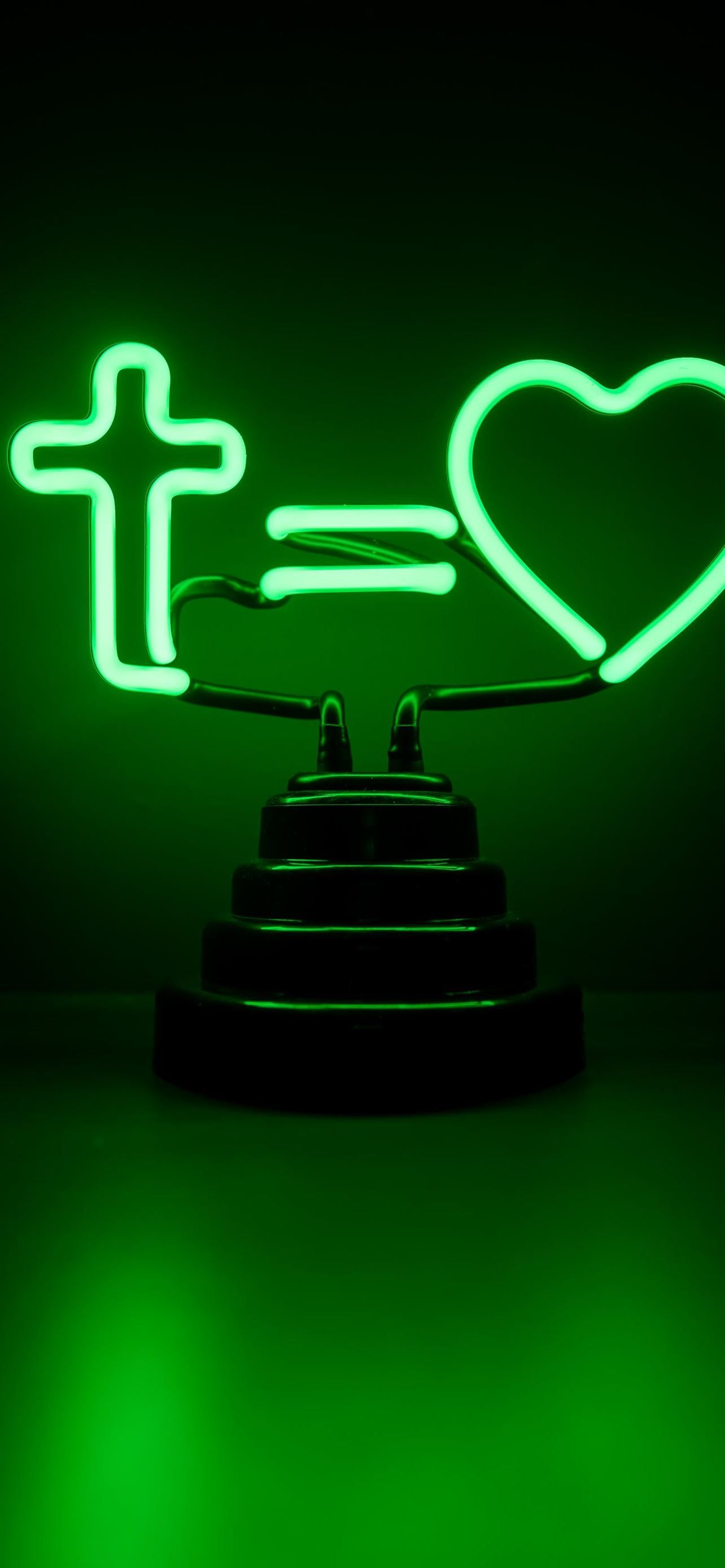 A green neon sign with a cross and a heart. - Neon green