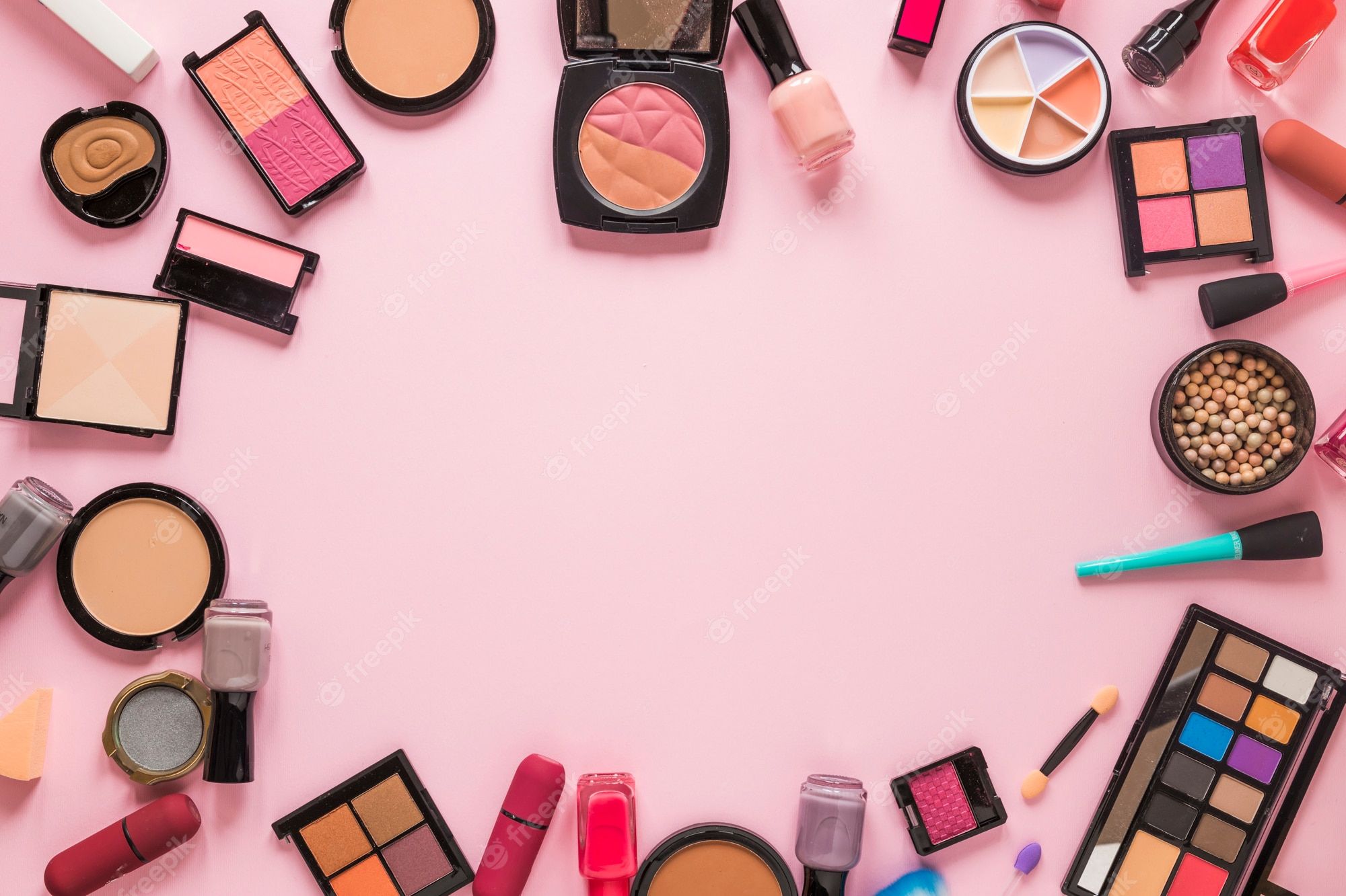 A variety of makeup products arranged in a circle on a pink background - Makeup