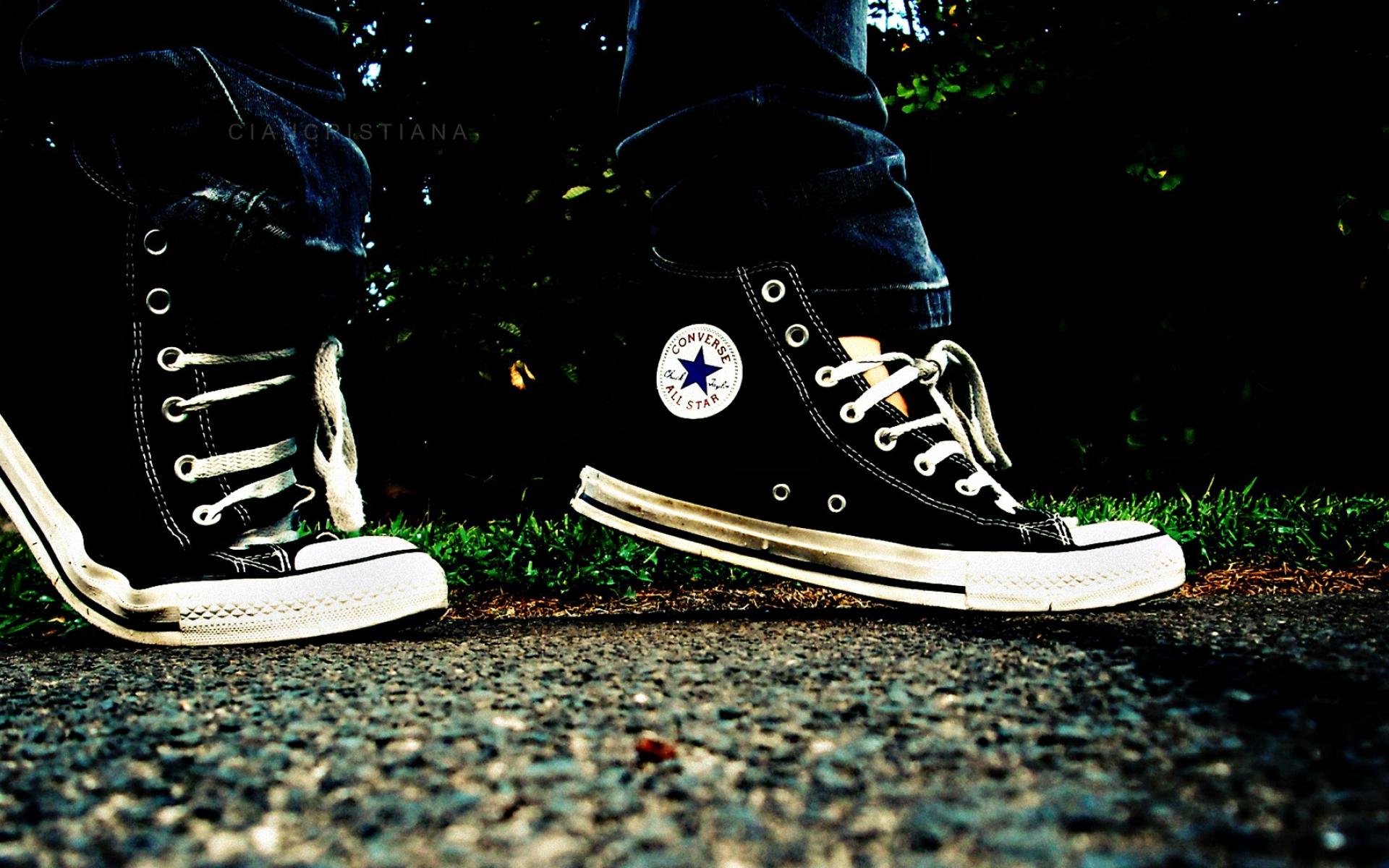 Black Converse All Star shoes on a pavement - Converse