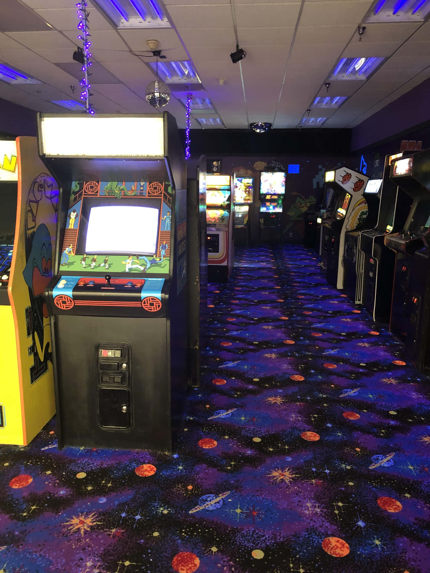 Download Arcade Machines In A Room With Purple Carpet Wallpaper