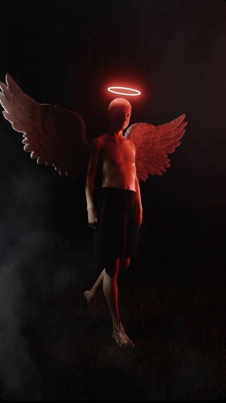 A man with wings and a halo standing in the dark. - Wings