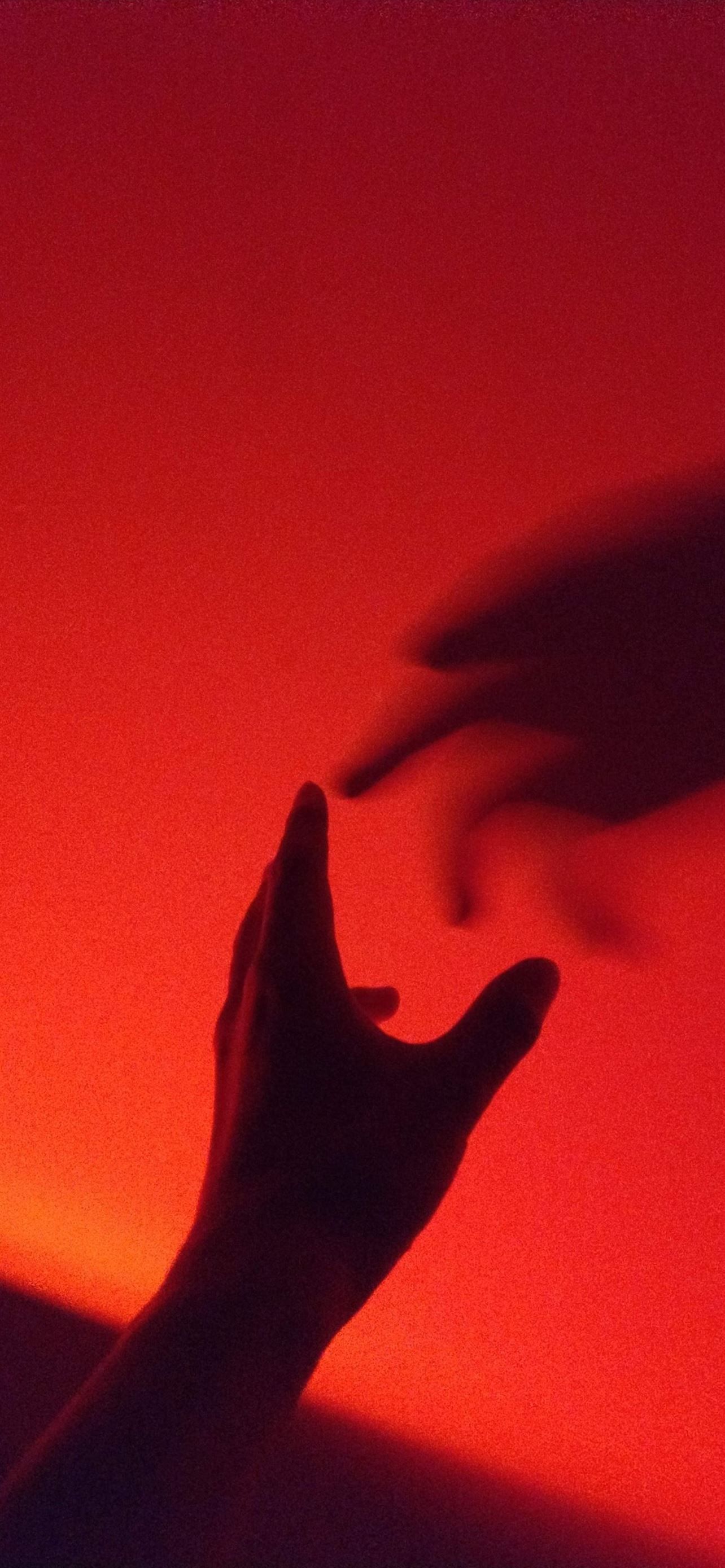 A red image with two hands reaching out to each other. - Shadow