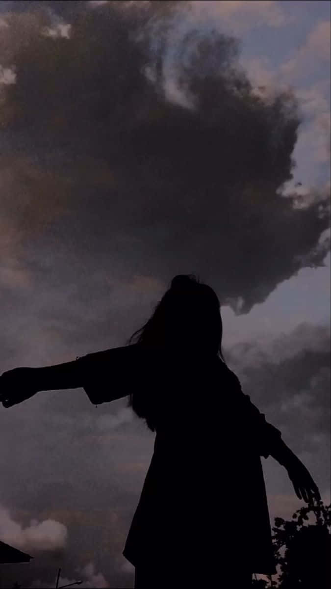 A girl's silhouette against a cloudy sky - Shadow