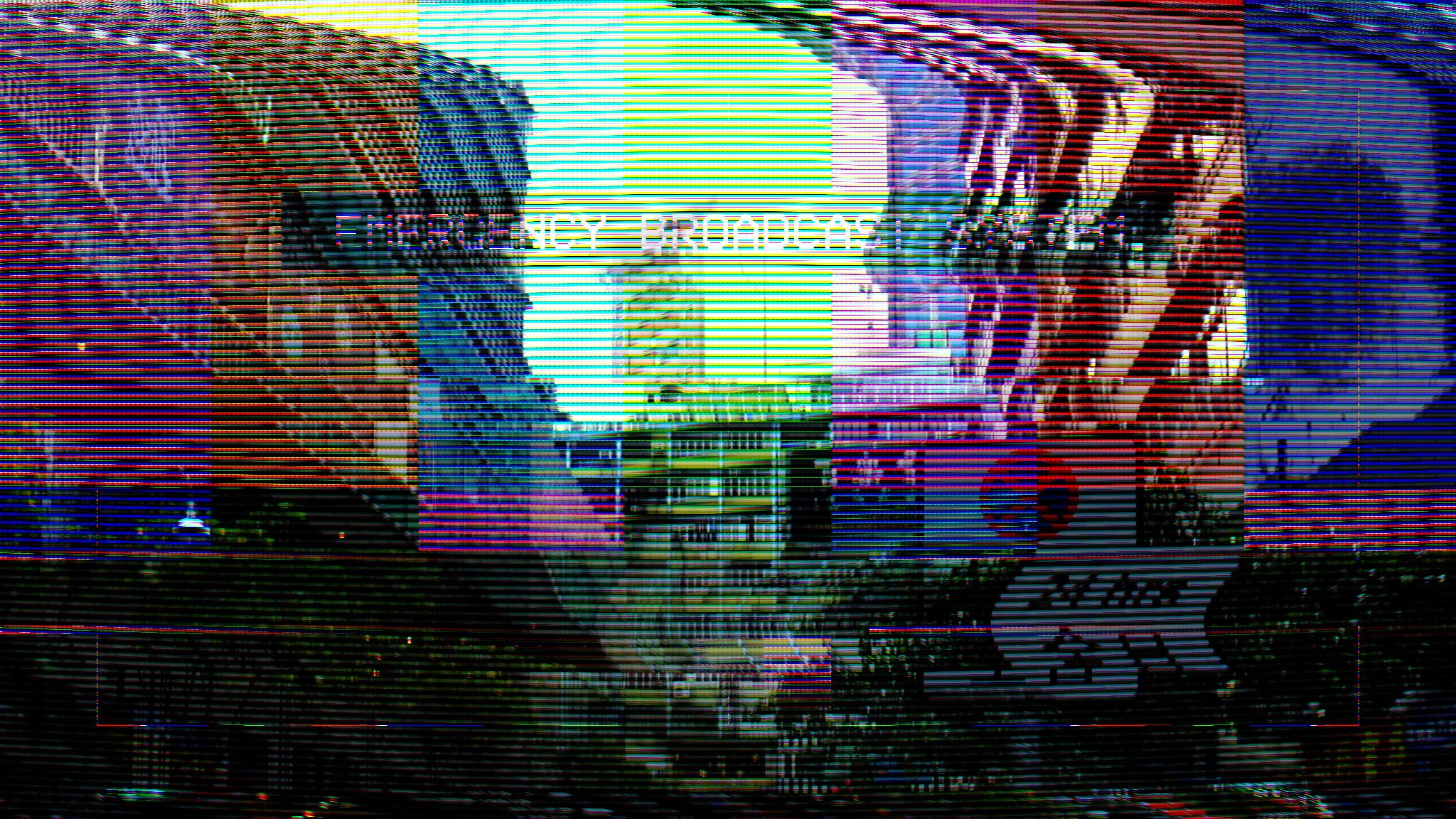 A man is shown on a television screen with static all over it. - Glitch