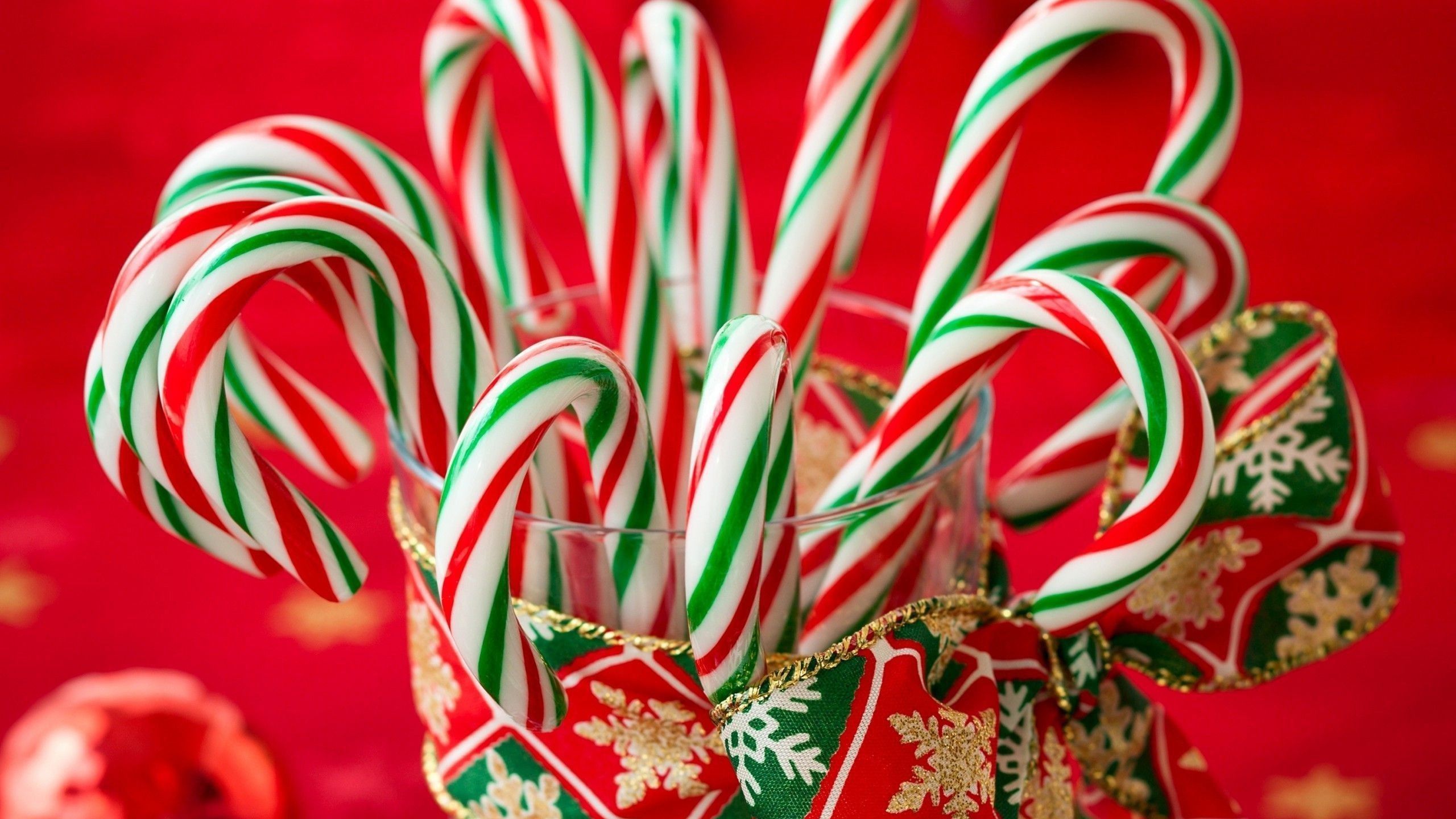 A glass full of red and green striped candy canes. - Candy cane