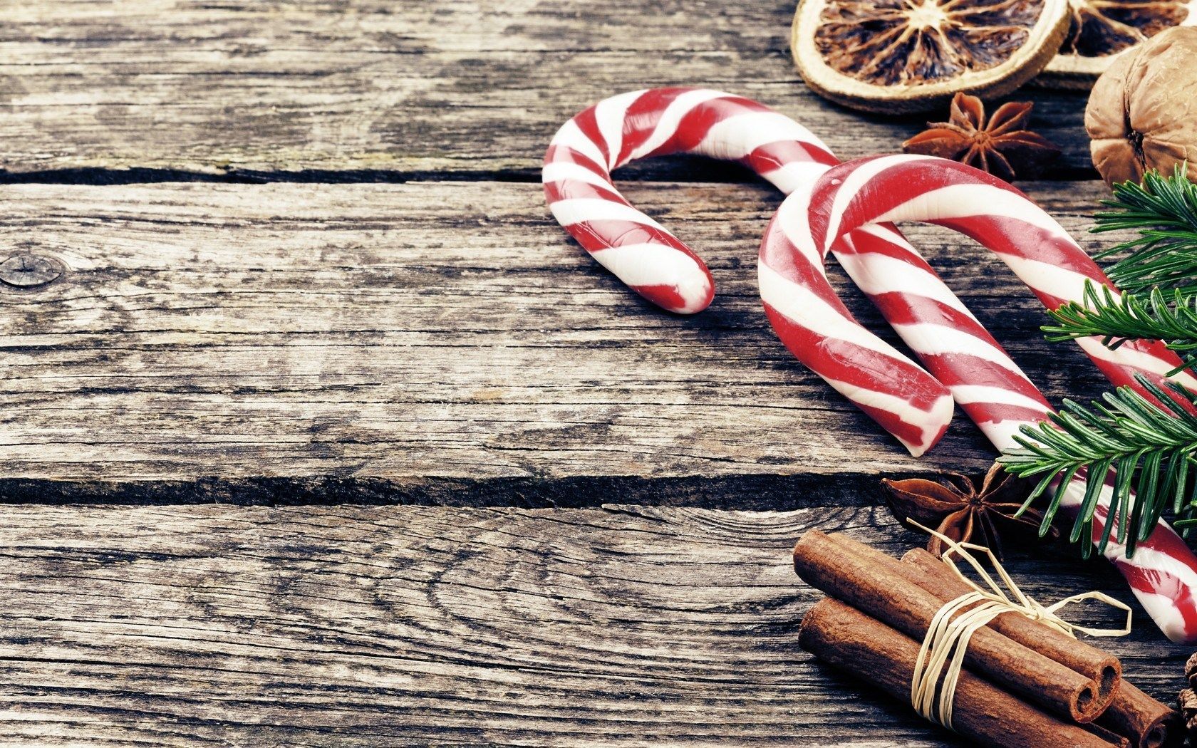 A candy cane on a wooden table with spices - Candy cane