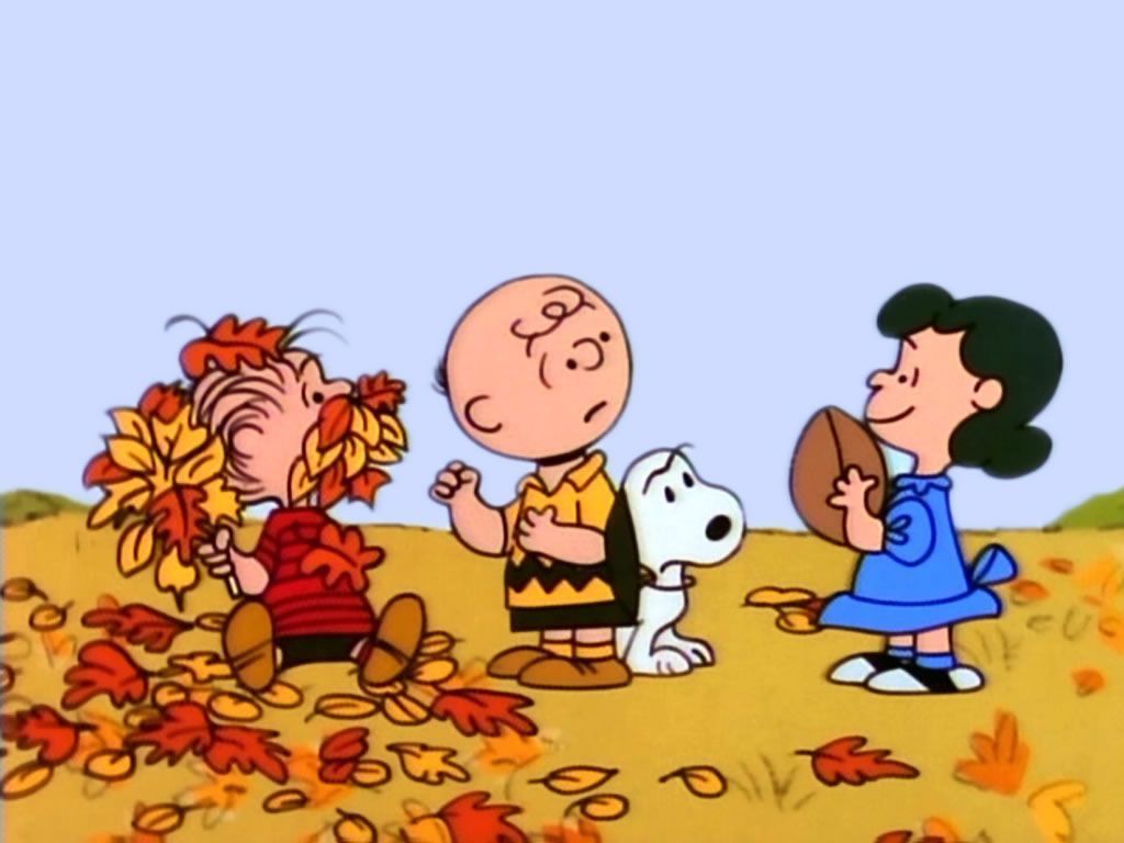 Charlie Brown, Snoopy, and Lucy are standing in a pile of leaves. - Charlie Brown
