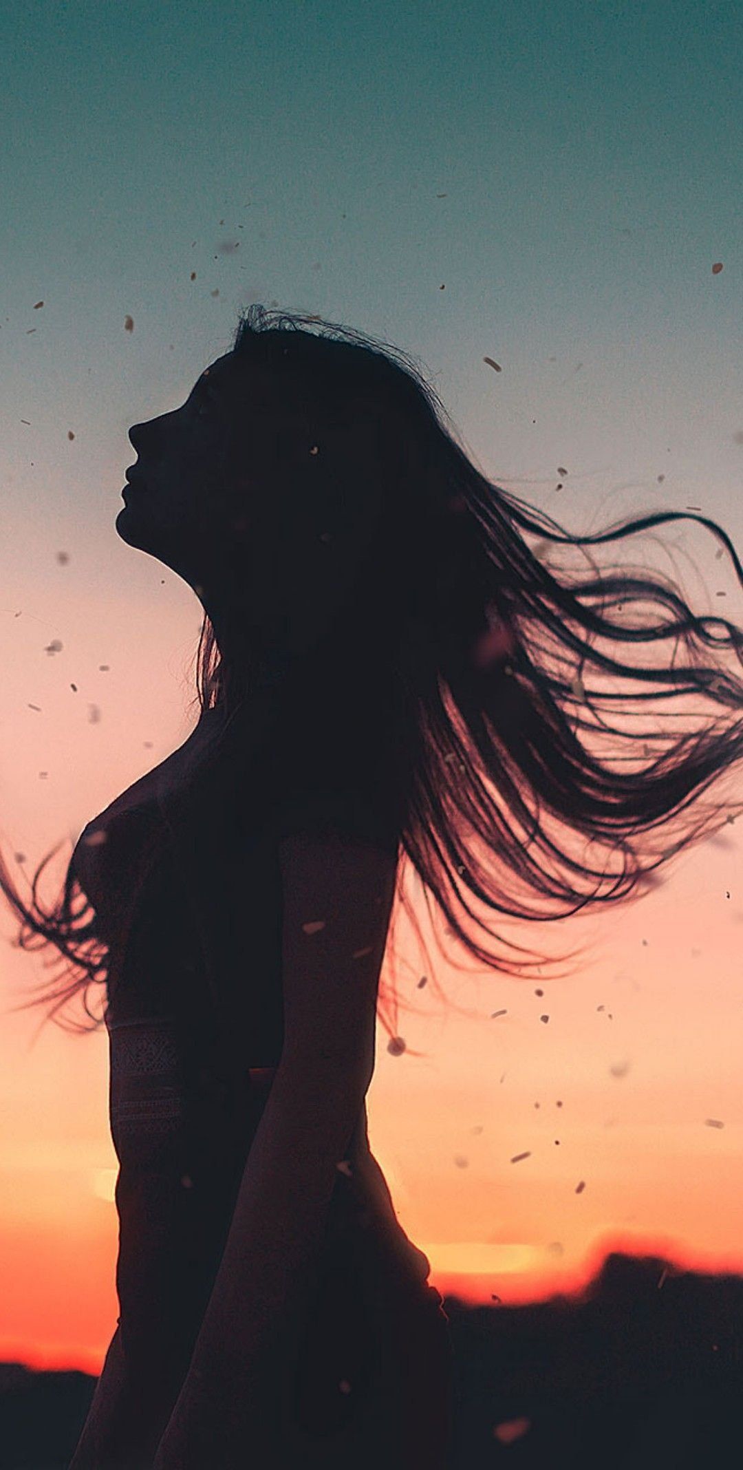 IPhone wallpaper of a woman with hair blowing in the wind at sunset - Shadow