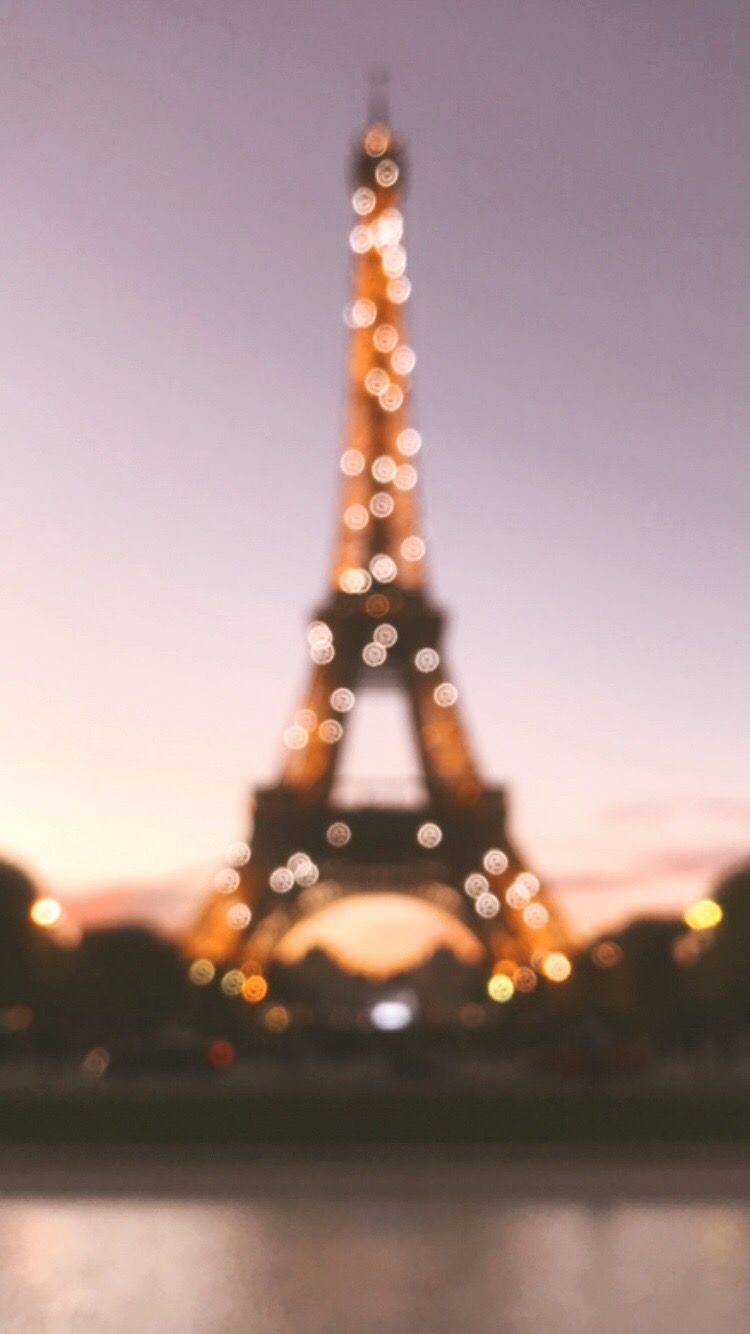 A blurry photo of the Eiffel Tower at night. - Eiffel Tower