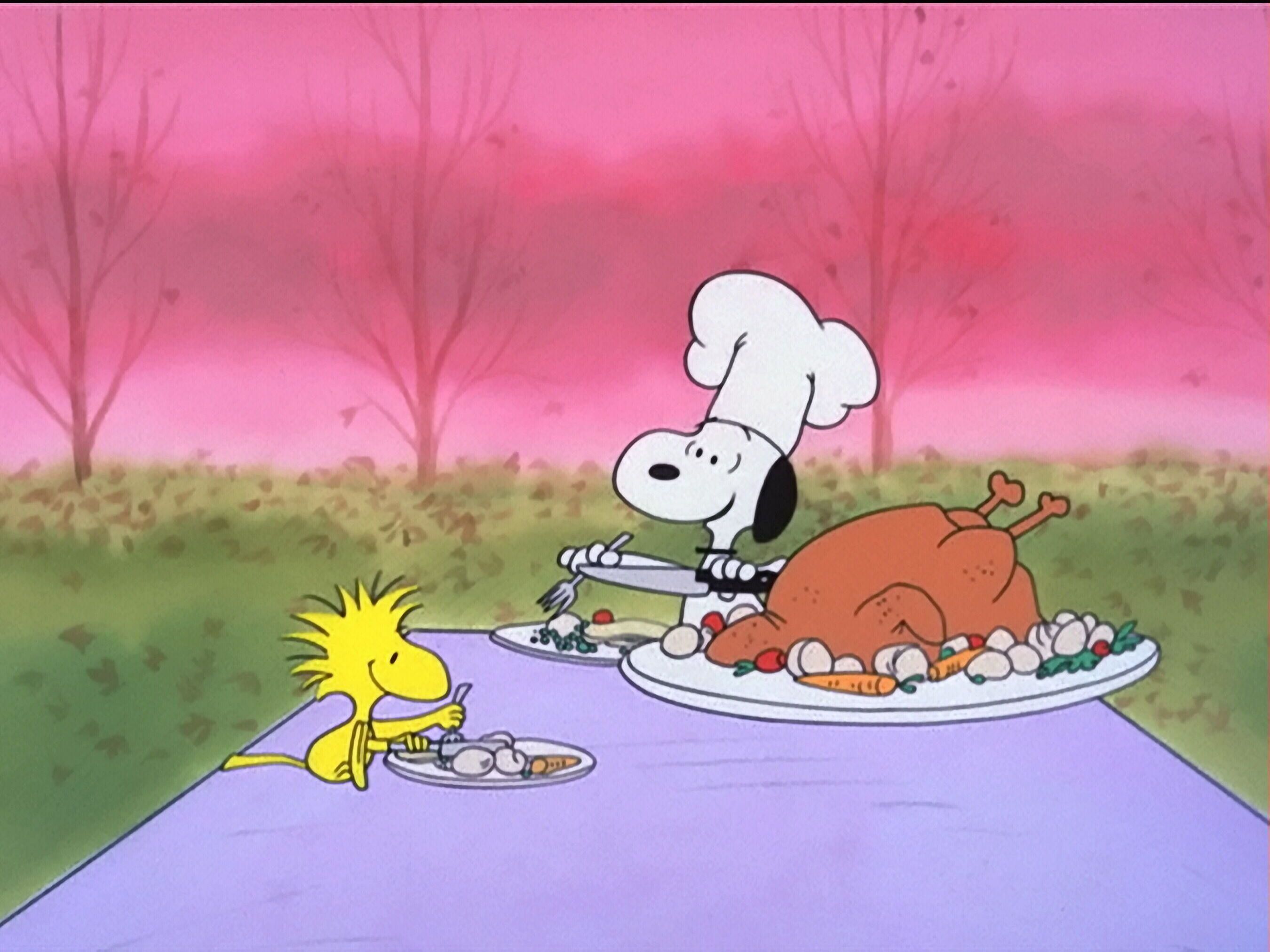 A cartoon character is sitting at the table with food - Charlie Brown