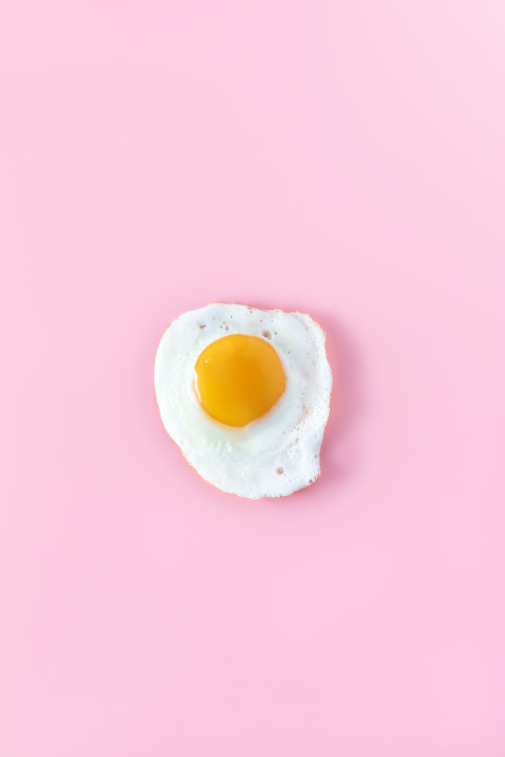 A single egg on top of pink background - Egg