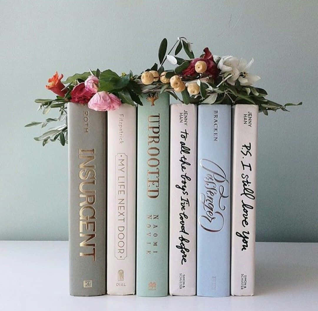A stack of books with flowers on top - Books
