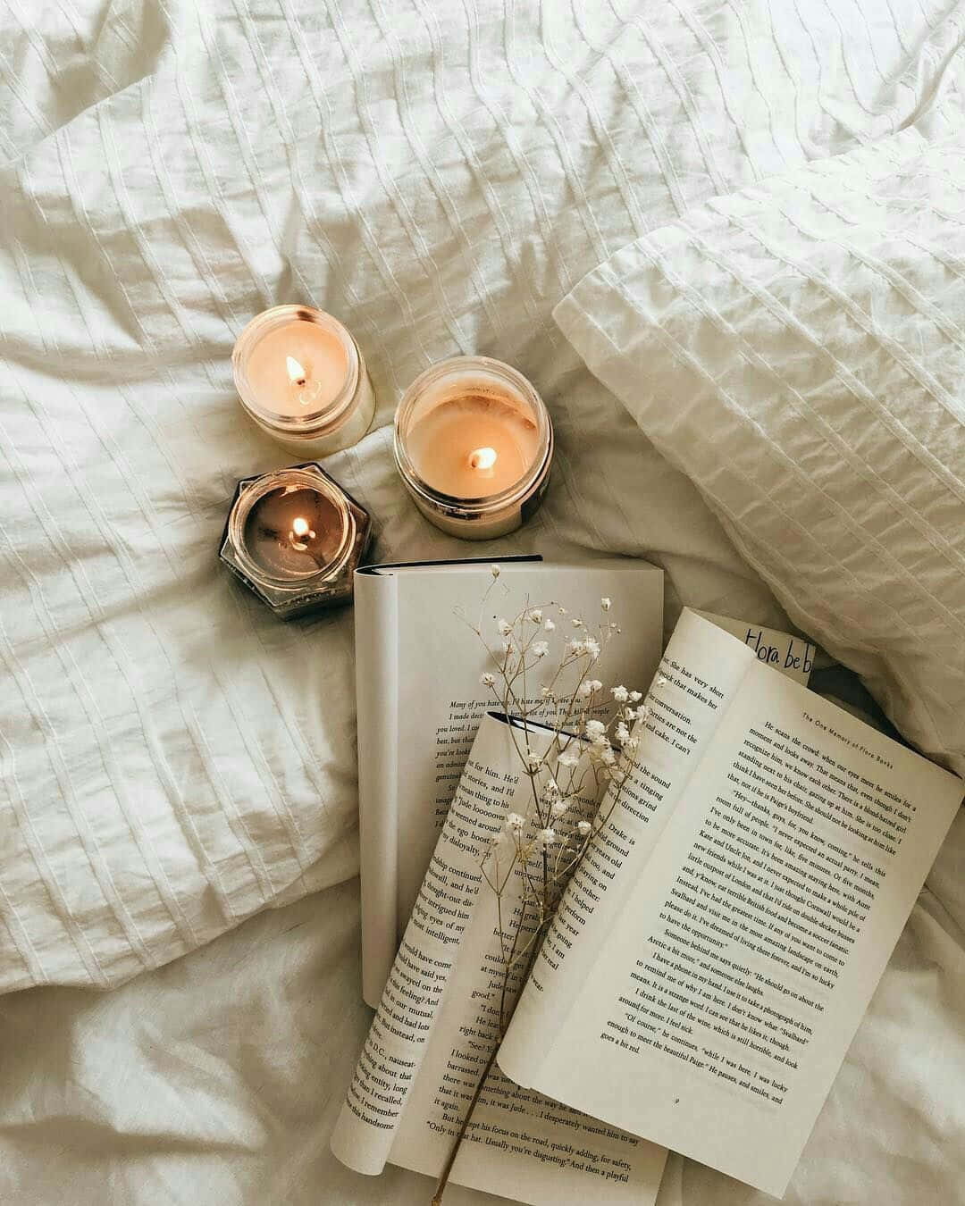 Download A Book, Candles, And Flowers On A Bed