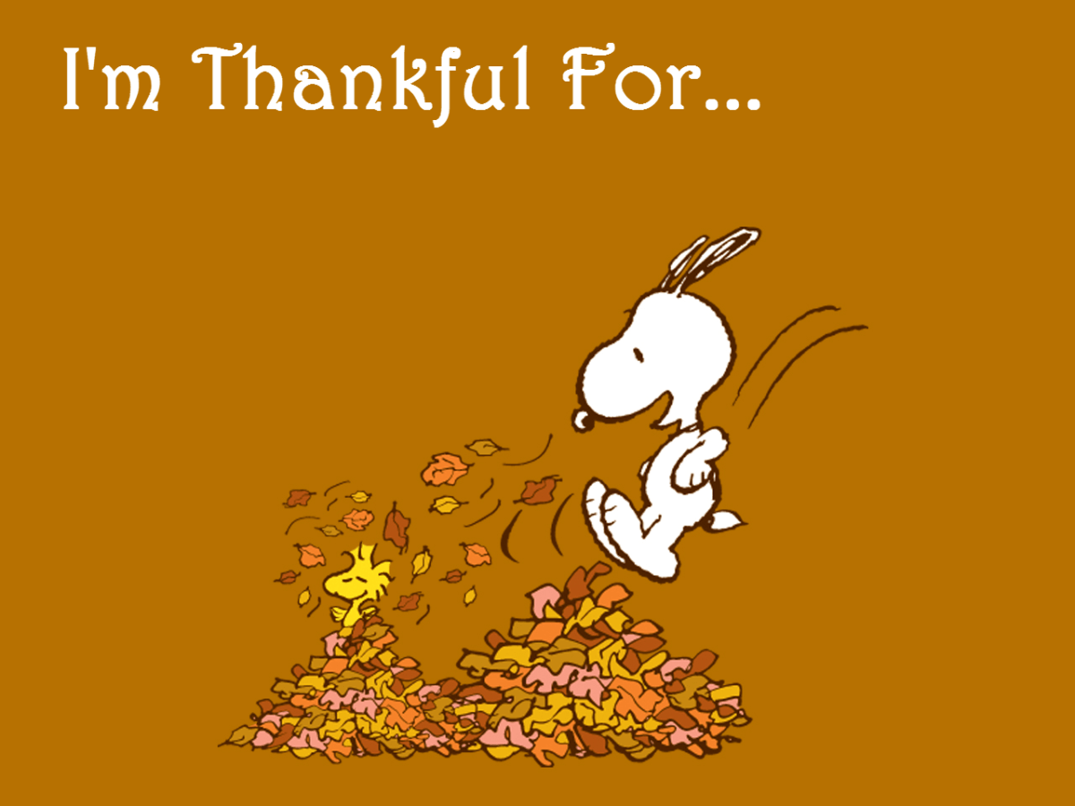 A cartoon character is running through leaves with the words i'm thankful for - Charlie Brown