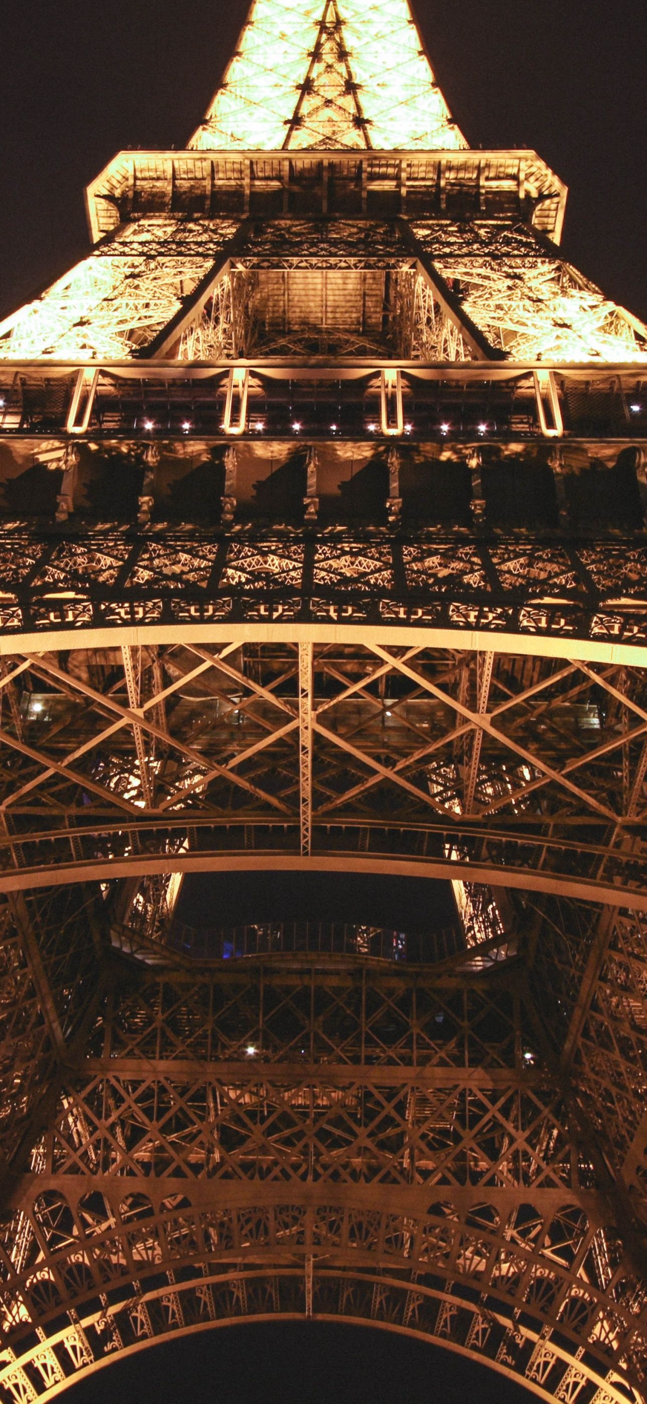 A night view of the Eiffel Tower, looking up from the ground. - Paris, Eiffel Tower