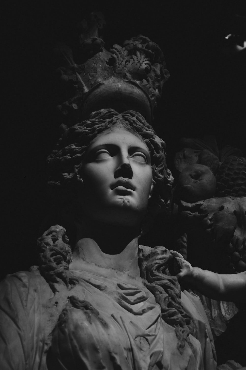 A black and white photo of a sculpture of a woman with a crown. - Statue