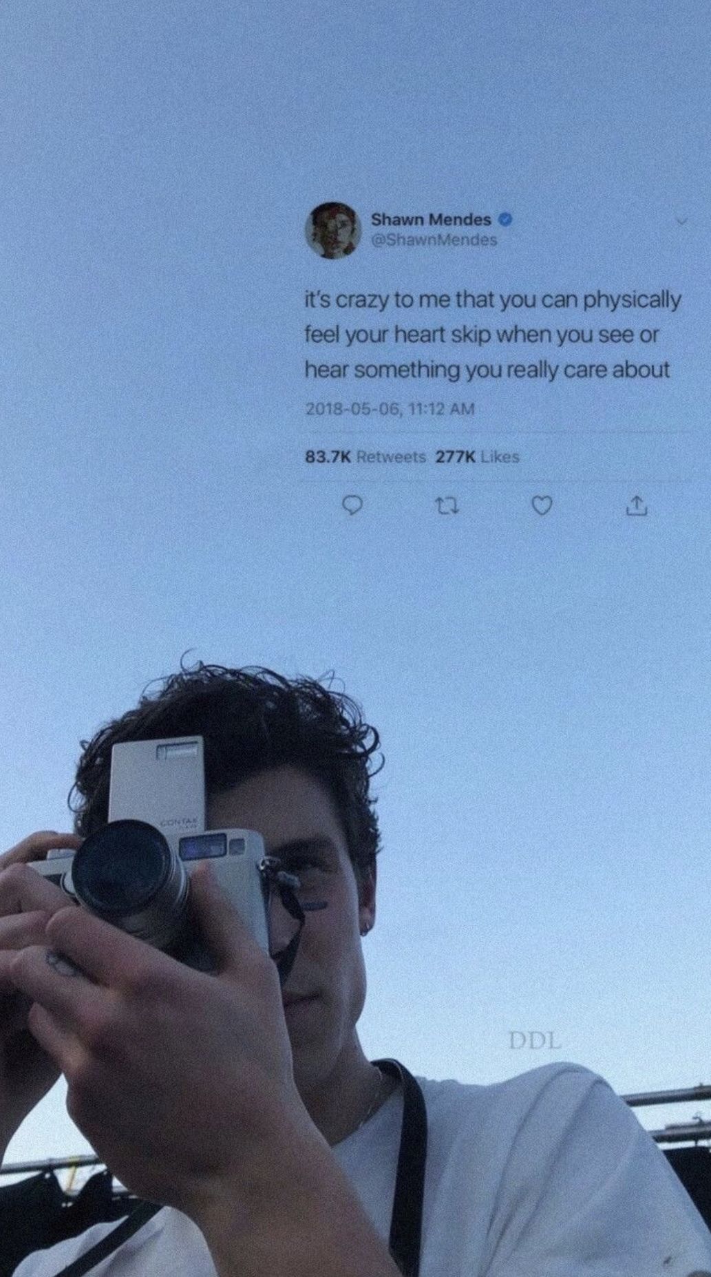 A selfie of Shawn Mendes holding a camera and a tweet from him about physically feeling your heart skip when you see or hear something you really care about - Shawn Mendes