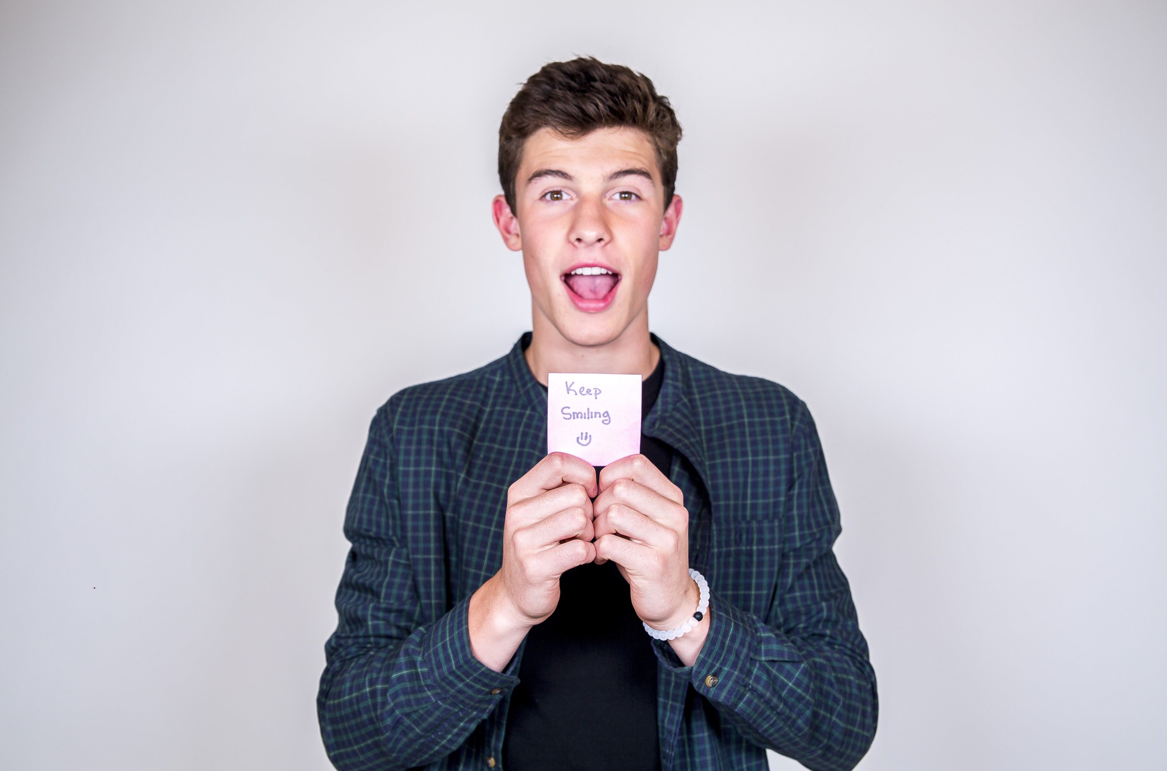 Shawn Mendes holding a note that says keep smiling - Shawn Mendes