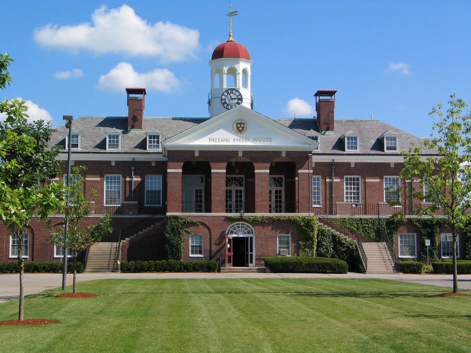 A large brick building with a red dome and a clock on the front. - Harvard