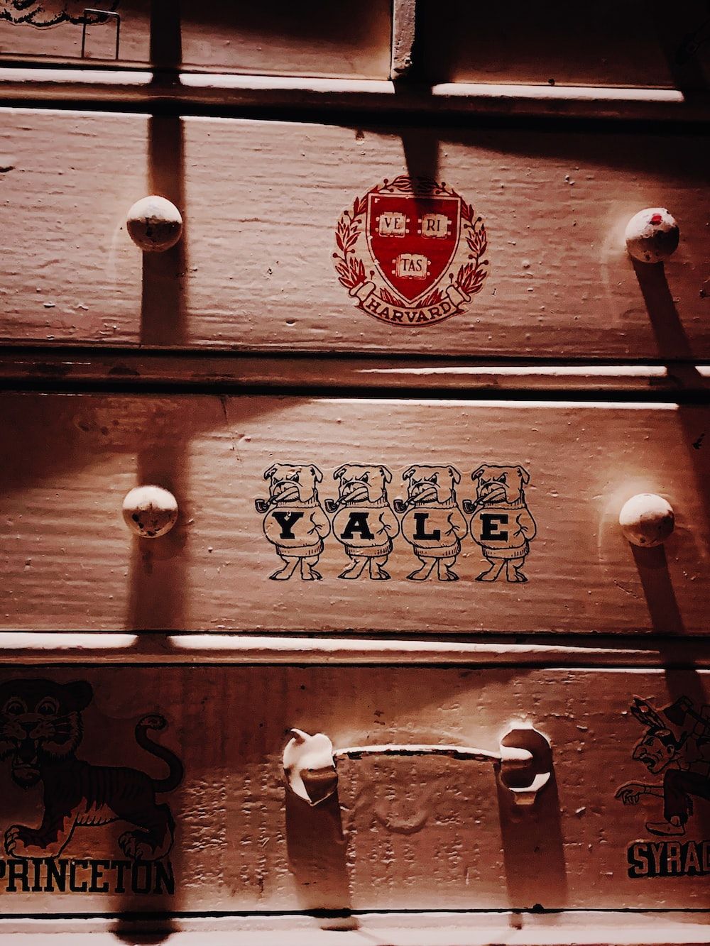 A drawer with a sticker of the Yale logo on it. - Harvard