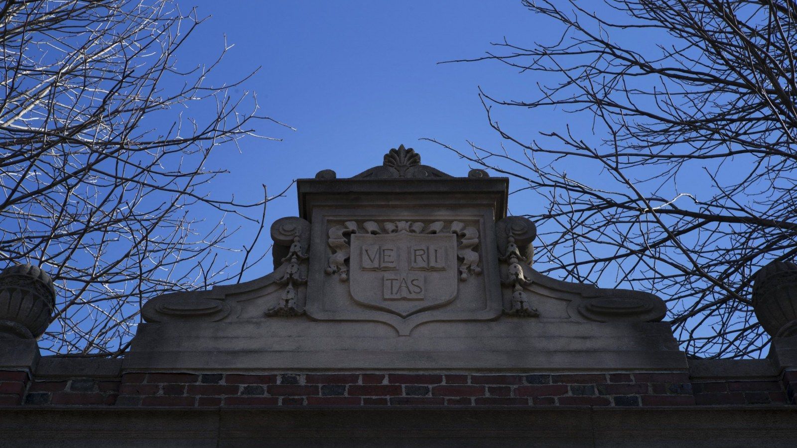 A stone sign on a brick wall reads 